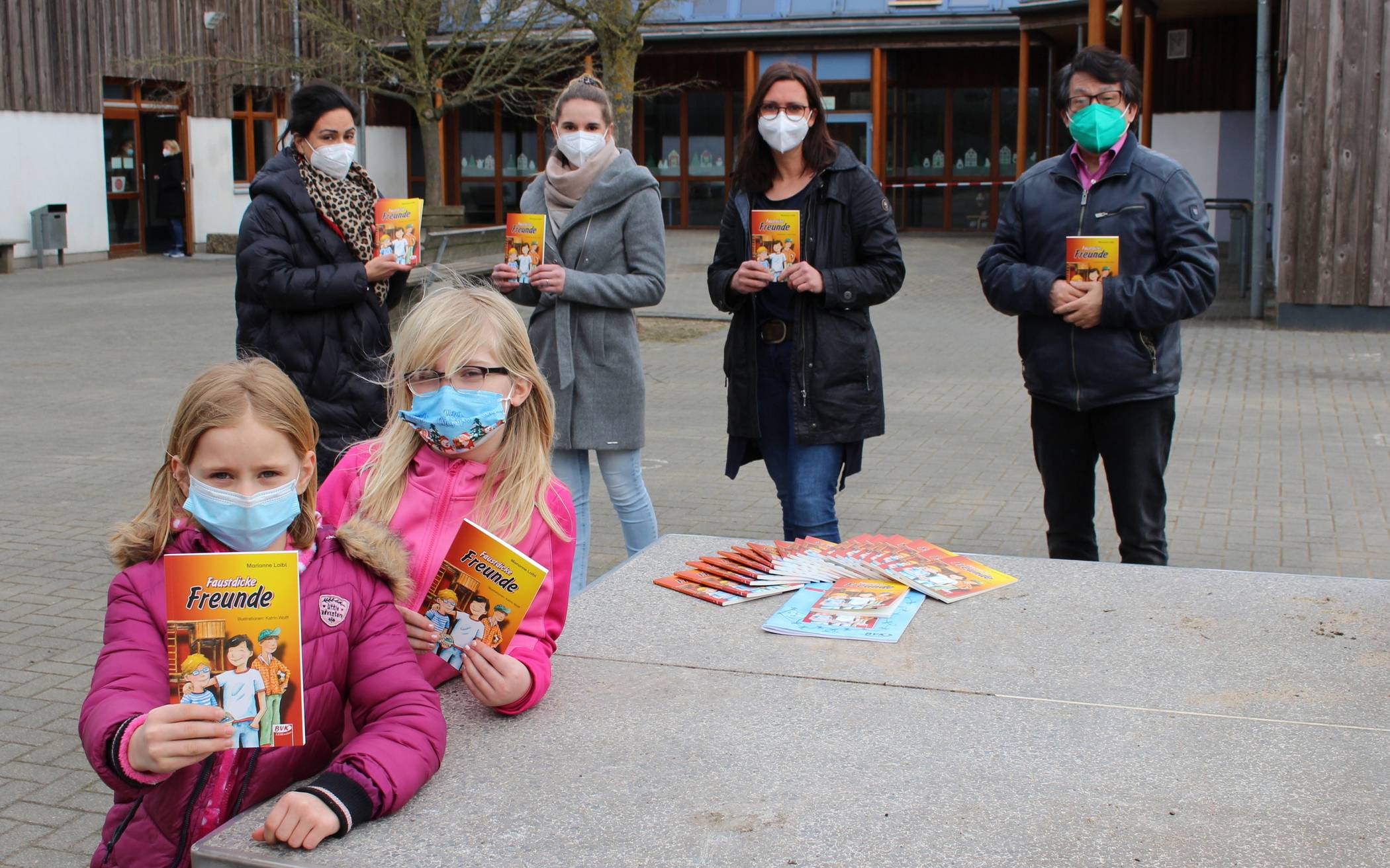  Lesestoff für die Grundschule Wekeln: „Faustdicke Freunde“ heißt das Buch, dass der Rotary Club nun an Lehrer und Schüler überreichen konnte. Mit den beiden Grundschülerinnen freuen sich (im Hintergrund) Dr. Semira Talimi vom Rotary Club, Lehrerin Janna Poppenburg, Rektorin Esther Wagner und Yine Zhang, Präsident des Rotary Clubs (von links). 