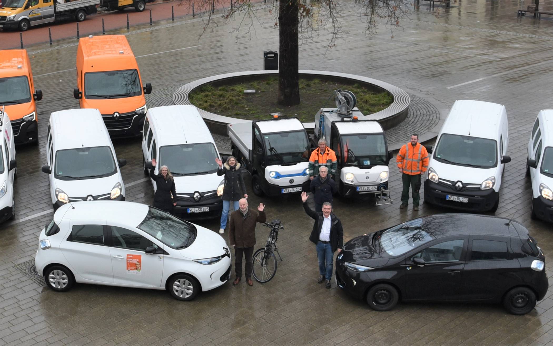Bürgermeister Dietmar Heyde (vorne rechts) und der 1. Beigeordnete Dieter Paus (vorne links) stellten zusammen mit dem kaufmännischen Leiter des DLB, Frank Rumpp (2. Reihe Mitte), die eFahrzeugflotte der Stadt Rheinberg inkl. des DLB auf dem Großen Markt vor.
