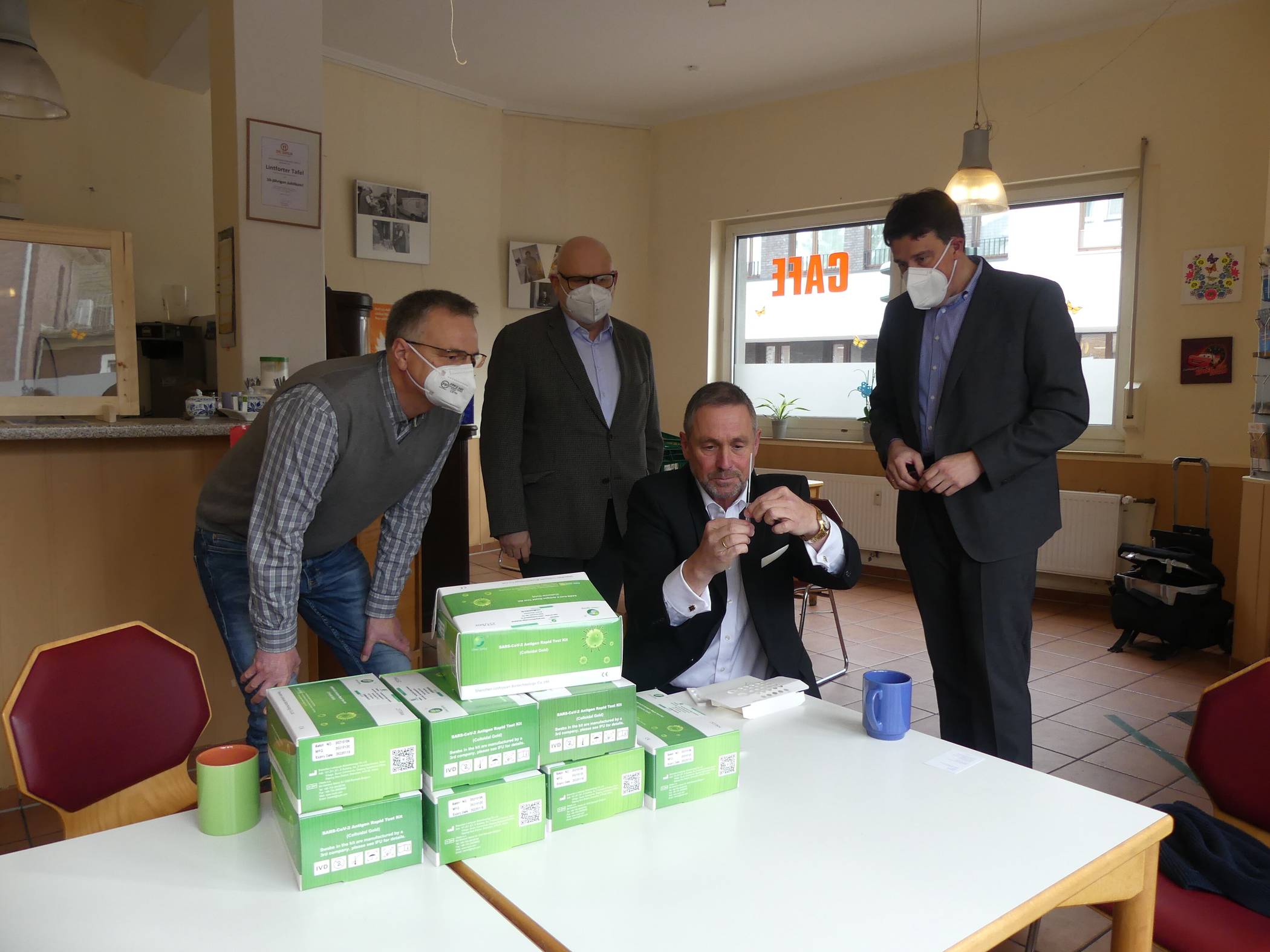  Guido Lohmann kennt sich bestens mit der Materie aus, in der Volksbank sind die Schnelltests bei den Mitarbeiter*innen bereits seit rund drei Wochen im Einsatz. Wolfgang Krause, Jürgen Voß (beide Tafel Kamp-Lintfort) und René Schneider (v.l.) beobachten gespannt, wie der Vorstandsvorsitzende sich selbst testet. Ergebnis: negativ! 