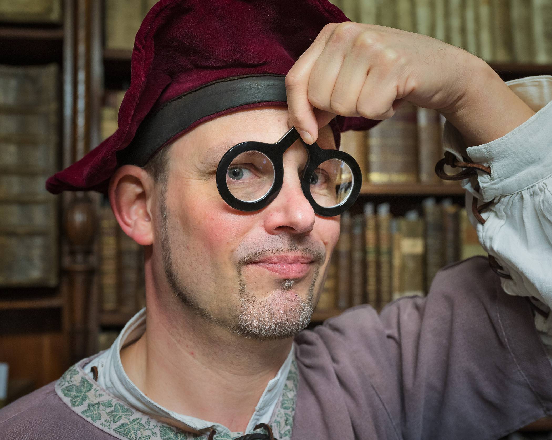  Stilecht: Museumspädagoge Boris Schuffels setzt die bewegliche Nietbrille auf, die der Krefelder Optiker Georg Bruns entsprechend mittelalterlicher Vorlagen nachgebildet hat. 