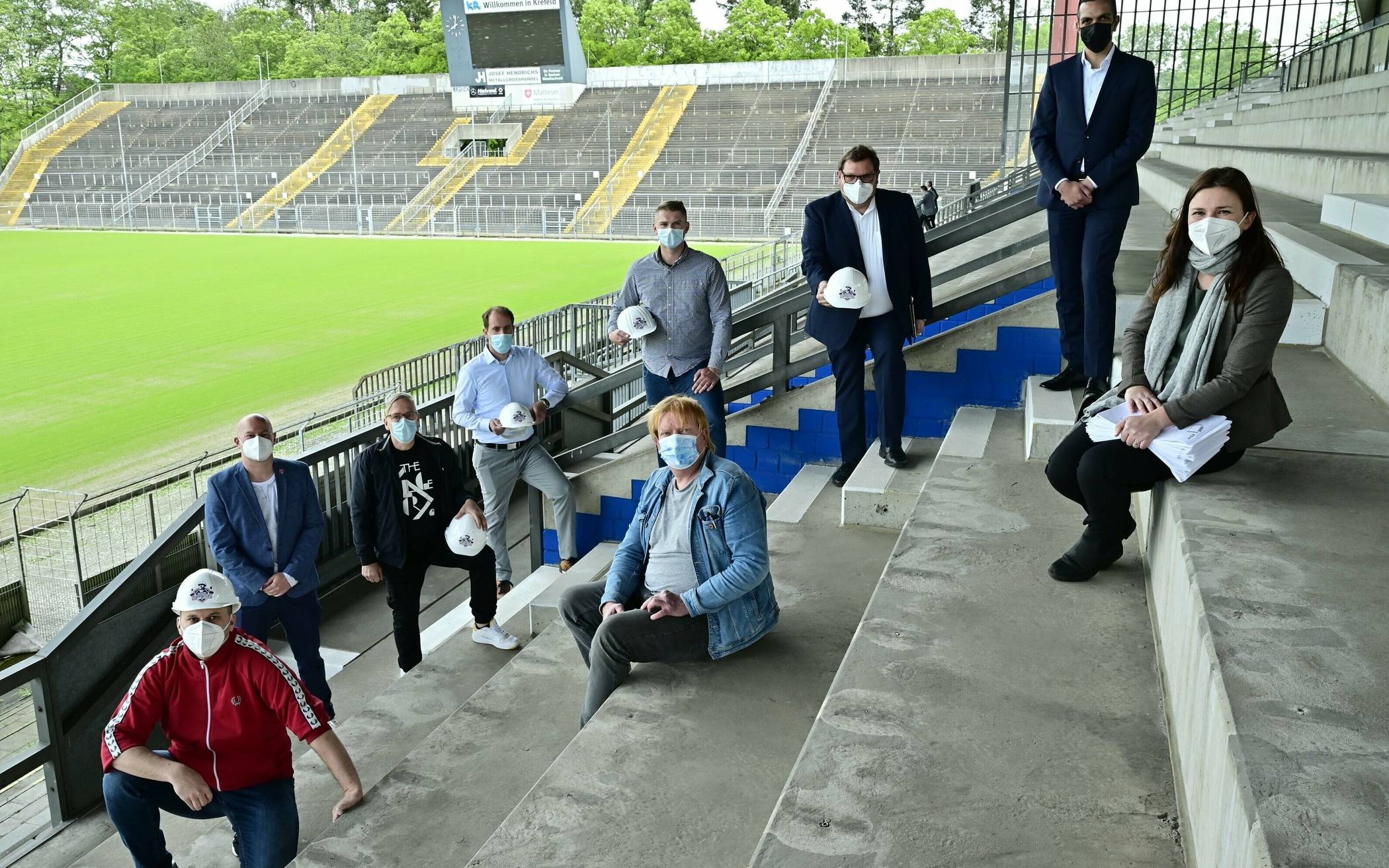  Präsentierten die Pläne der „Grotenburg Supporters“ (v.l.): Daniel Staude (KFC-Fan), André Schahidi (Pressesprecher KFC), Armin Korf (KFC-Fan), Martin Kühr (KFC-Fan), Marius Savic (KFC-Fan), Michael Eigenbrodt (sitzend, KFC-Fan), Oberbürgermeister Frank Meyer, Rachid Jaghou (Leiter des Fachbereichs Gebäudemanagement), Sabine Schmidt (Projektleiterin Grotenburg).					Foto: Stadt Krefeld 