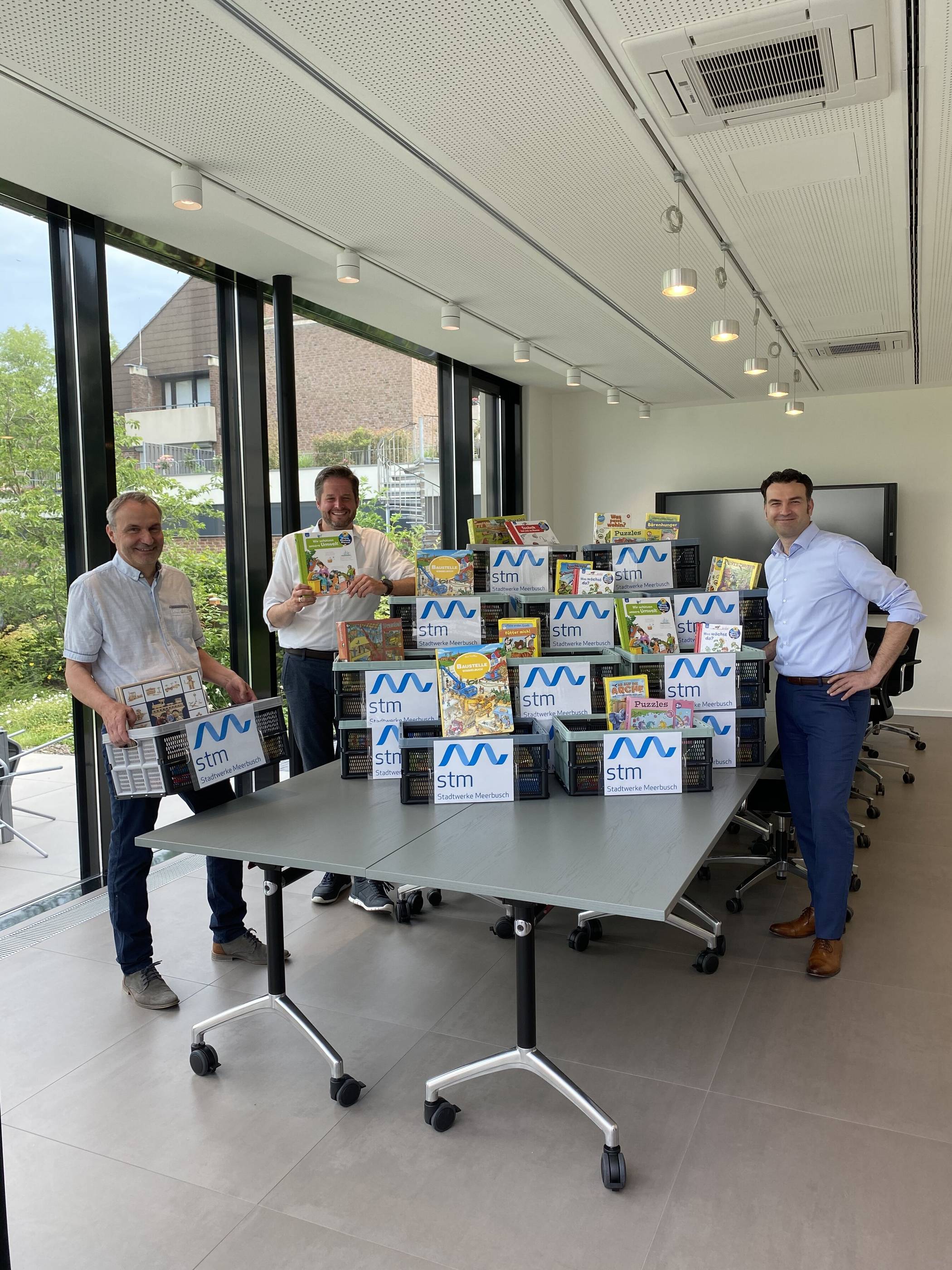 Tafil Pufja (r.) übergab gemeinsam mit Meerbuschs Bürgermeister Christian Bommers symbolisch einige Stadtwerke-Spielekisten an den Leiter des Fachbereichs soziale Hilfen und Jugend Peter Annacker. 