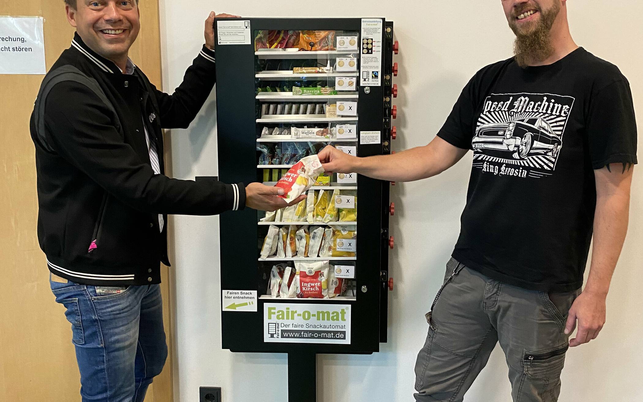 Treffen am „Fair-o-mat“ im Technischen Rathaus: Bürgermeister Chris Pakusch gibt seinem Klimamanager Marcell Gellißen eine Runde fair gehandelter Drops aus. 