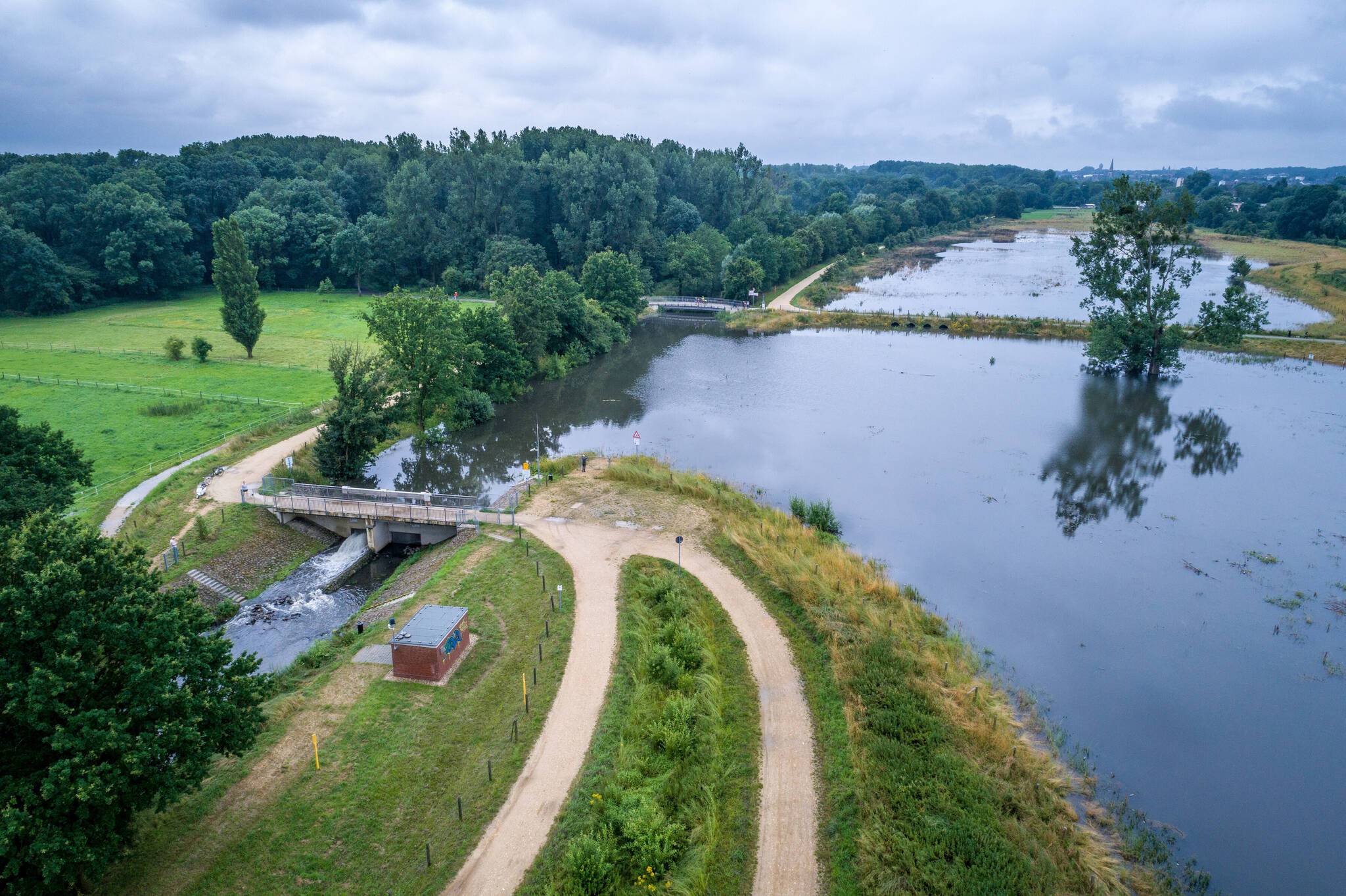  Das eingestaute Hochwasserrückhaltebecken Geneicken in Mönchengladbach nach dem Starkregen. Links die Niers mit dem Wasserstand vor und hinter dem regulierenden Wehr.  
