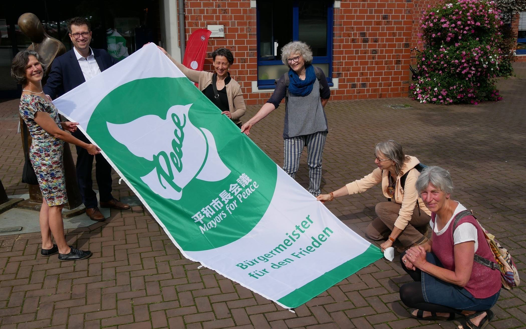  Ein Friedens-Zeichen setzte Nettetals Bürgermeister Christian Küsters mit der Flagge. Mit dabei Anthoula Kapnidou (3.v.l.) und Brigitte Hilgenfeld (l.). 