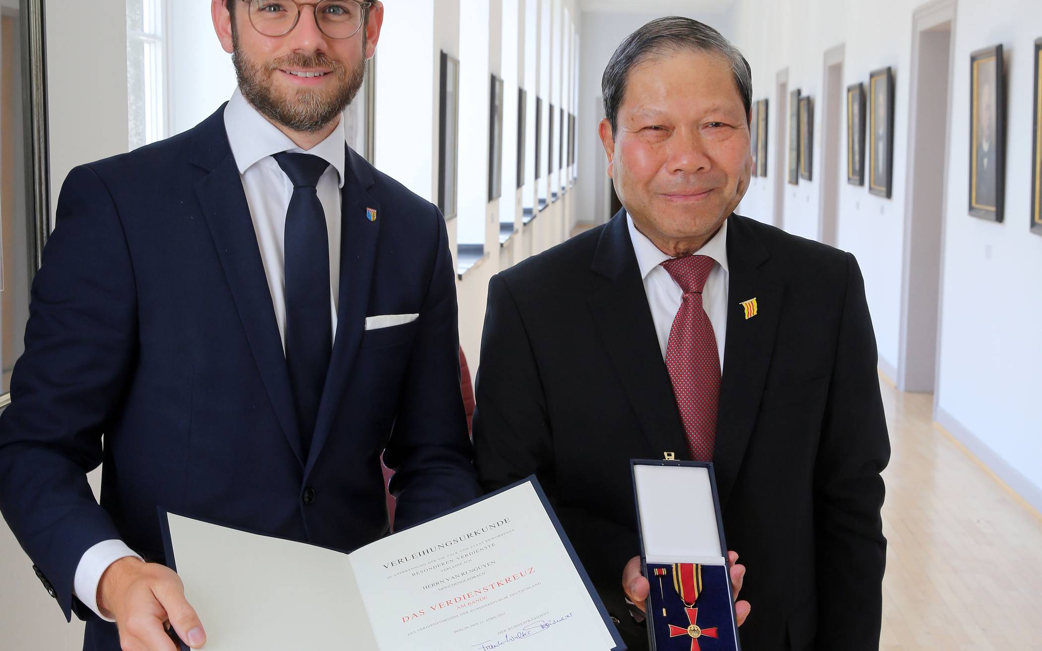 Oberbürgermeister Felix Heinrichs und der neue Träger des Bundesverdienstkreuzes am Bande, Van Ri Nguyen. 