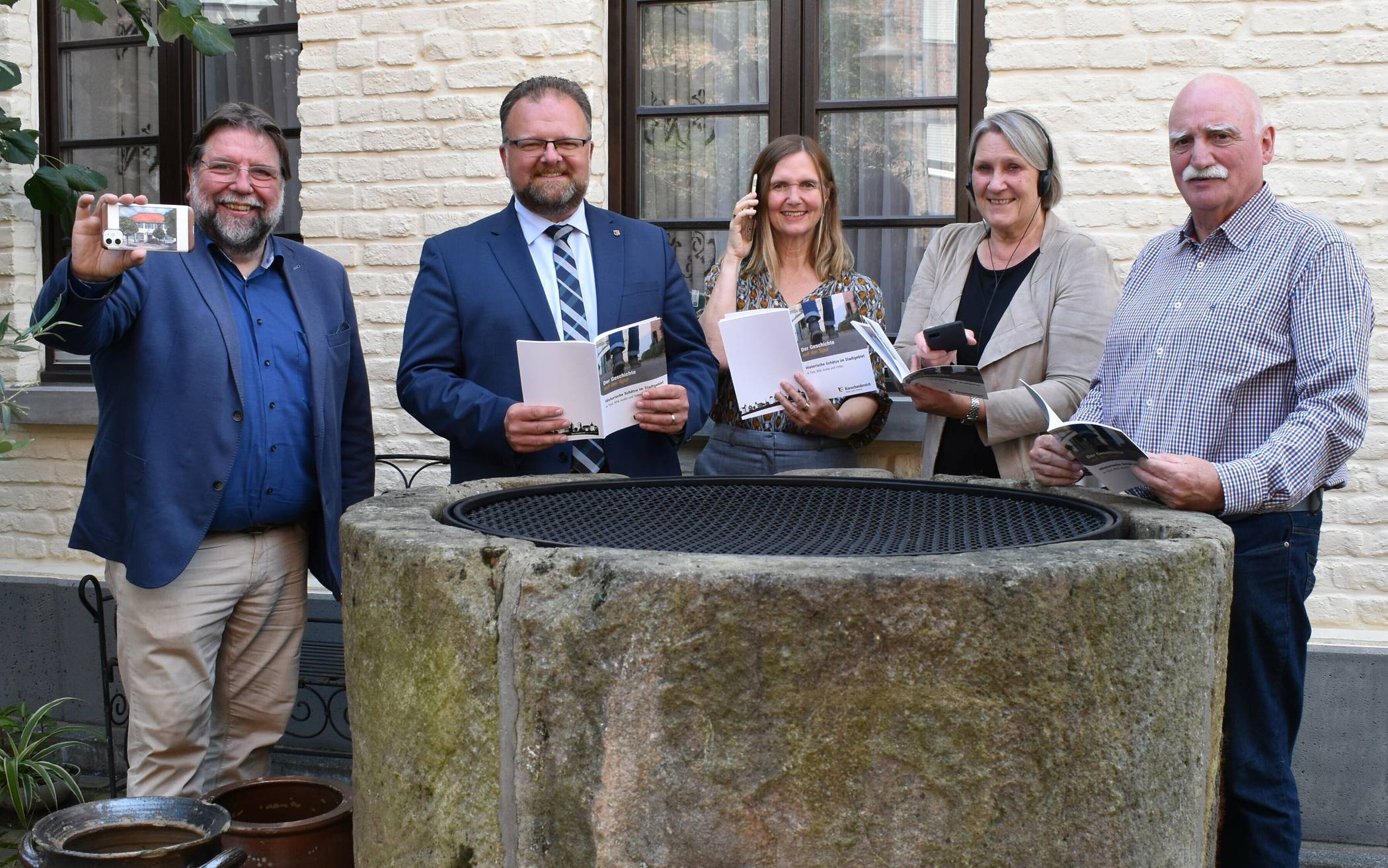 Mit der kostenlosen Broschüre kann man multimedial Altes neu entdecken. Dies testeten beim Pressetermin (v.l.) Denkmal-Besitzer Horst Thoren, Bürgermeister Marc Venten, Birgit Wilms (Mitarbeiterin der Pressestelle), Michaele Messmann (Leiterin des Kulturamtes und Stadtarchivs) und Denkmalschutzbeauftrager Günter Thoren. 