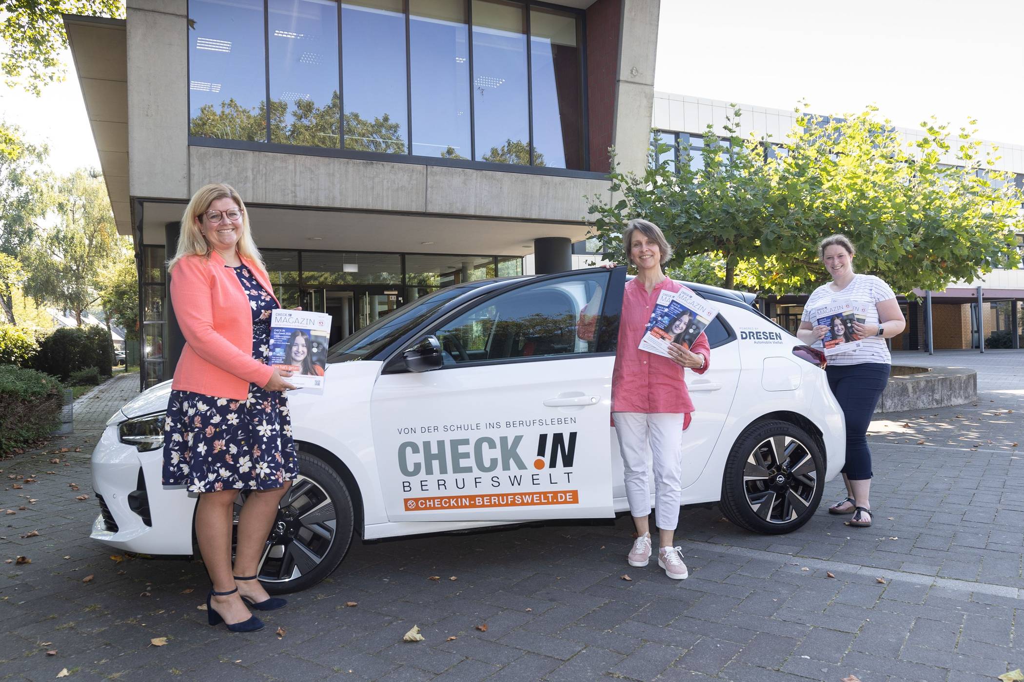 IHK-Geschäftsführerin Daniela Perner (l.) überbrachte die neuen Check In-Magazine zum Teil persönlich in die Schulen. Mit dem diesjährigen Kampagnenfahrzeug, einem rein elektrischen e-Corsa, verbindet Check In in diesem Jahr einen Fotowettbewerb für Schülerinnen und Schüler.  