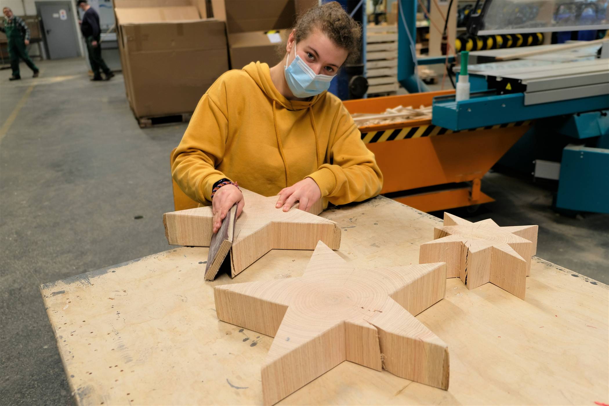  Anja Schiffer, Mitarbeiterin der Varius-Werkstätten, schleift die Holzsterne aus Roteiche. 