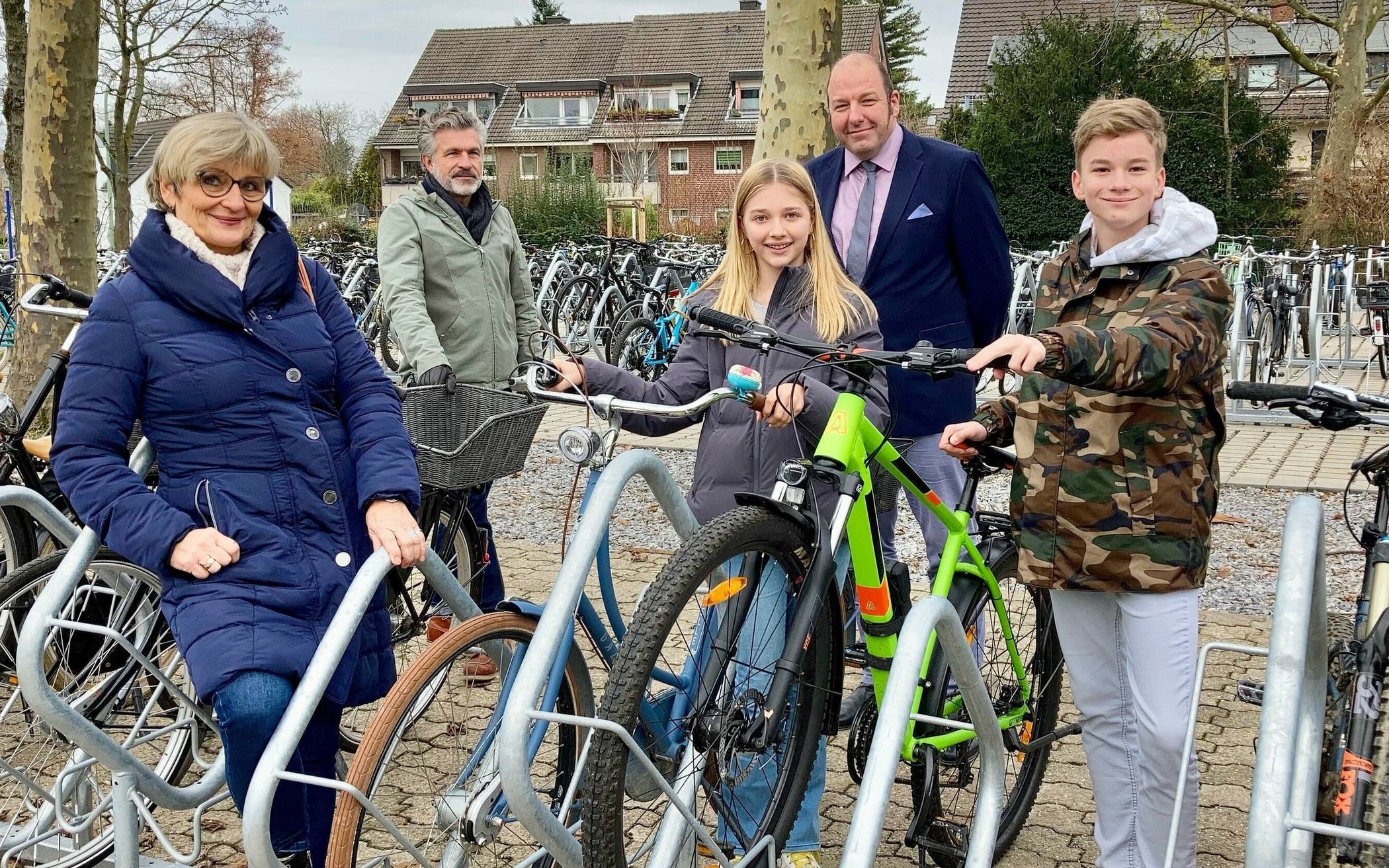  Dana Frey, Leiterin Stabsstelle Umwelt, Markus Weidemann, Servicebereich Grünflächen, und Schulleiter Christian Dölls (v.l.) an den neuen Fahrradständern auf dem Schulhof des Mataré-Gymnasiums. Mathilde und Florian aus der 7c fahren jeden Tag mit dem Rad zur Schule. 