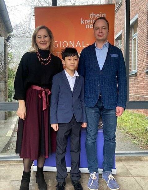 Oxana Koppers (Pianistin und Musikschulleitung), Zhou Jun Li (1. Preis mit Weiterleitung Landeswettbewerb) und Denis Kryukov (Dozent und Violinist) freuen sich über das gute Abschneiden der Musikschule Musicbox Oxana bei „Jugend musizert“. 
  