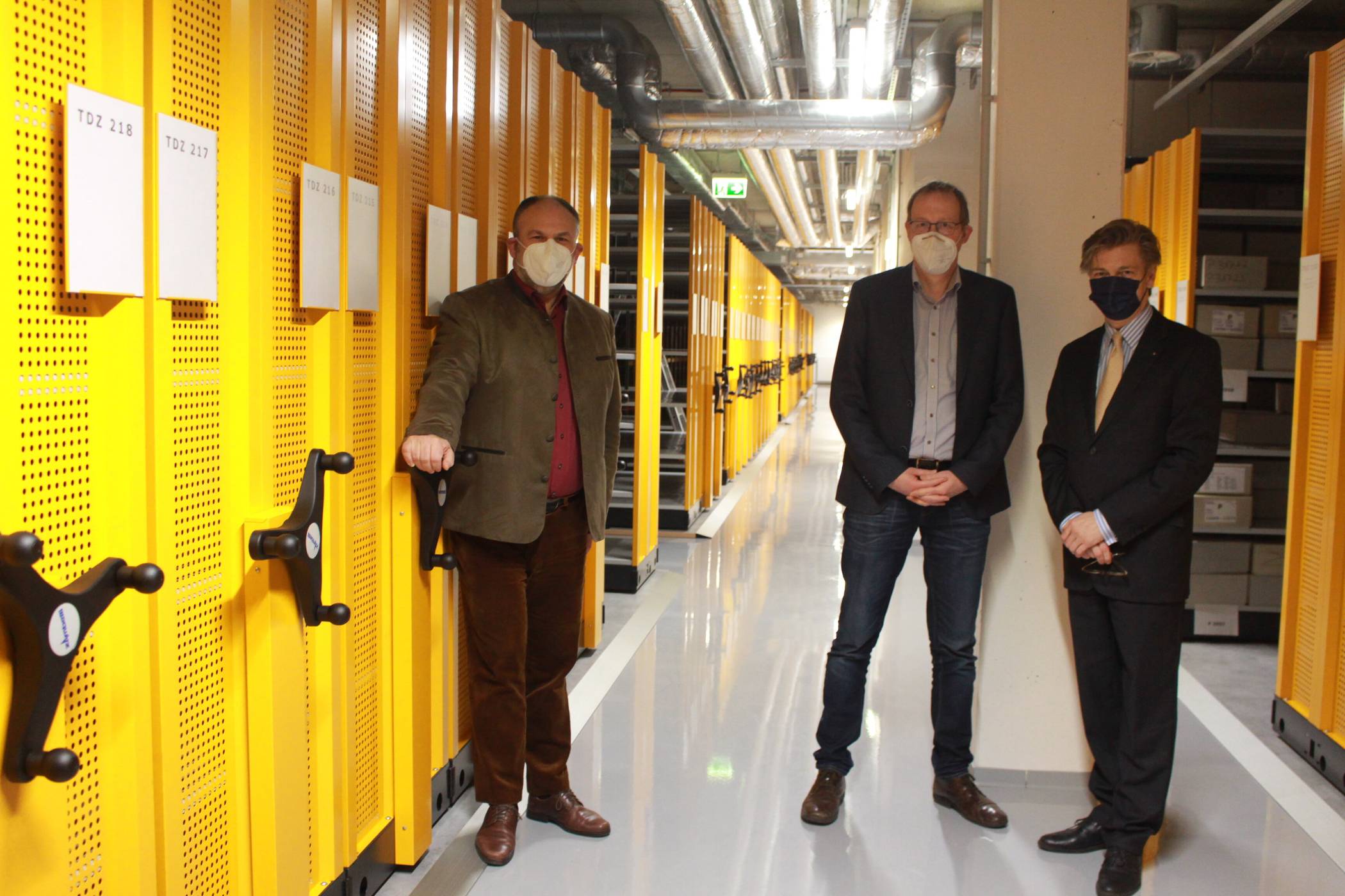  Scheinbar endlose Regalreihen: Der Leiter des Stadtarchivs Dr. Olaf Richter (r.) und sein Stellvertreter Dr. Christoph Moß (Mitte) zeigen Dr. Mark Steinert, Leiter der LVR-Archivberatung, das neue Magazin mit der vom LVR geförderten Regalanlage. Hier ist Platz für die Bestände der nächsten 30 Jahre. Foto: Müller   