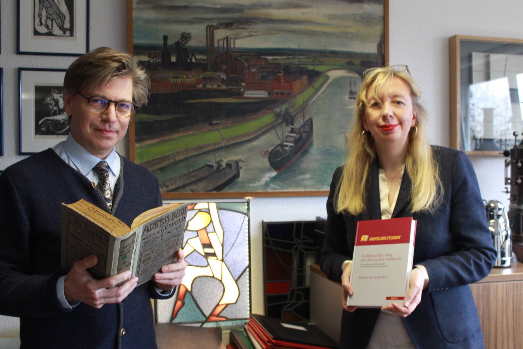 Studien zur Stadtgeschichte: Professorin Dr. Stefanie van de Kerkhof legt ein gewichtiges Buch zur Entwicklung Krefelds zur Großstadt vor. Stadtarchivar und Herausgeber Dr. Olaf Richter blickt in ein altes Adressbuch, das zur Studie wertvolle Hinweise enthält. Foto: Müller