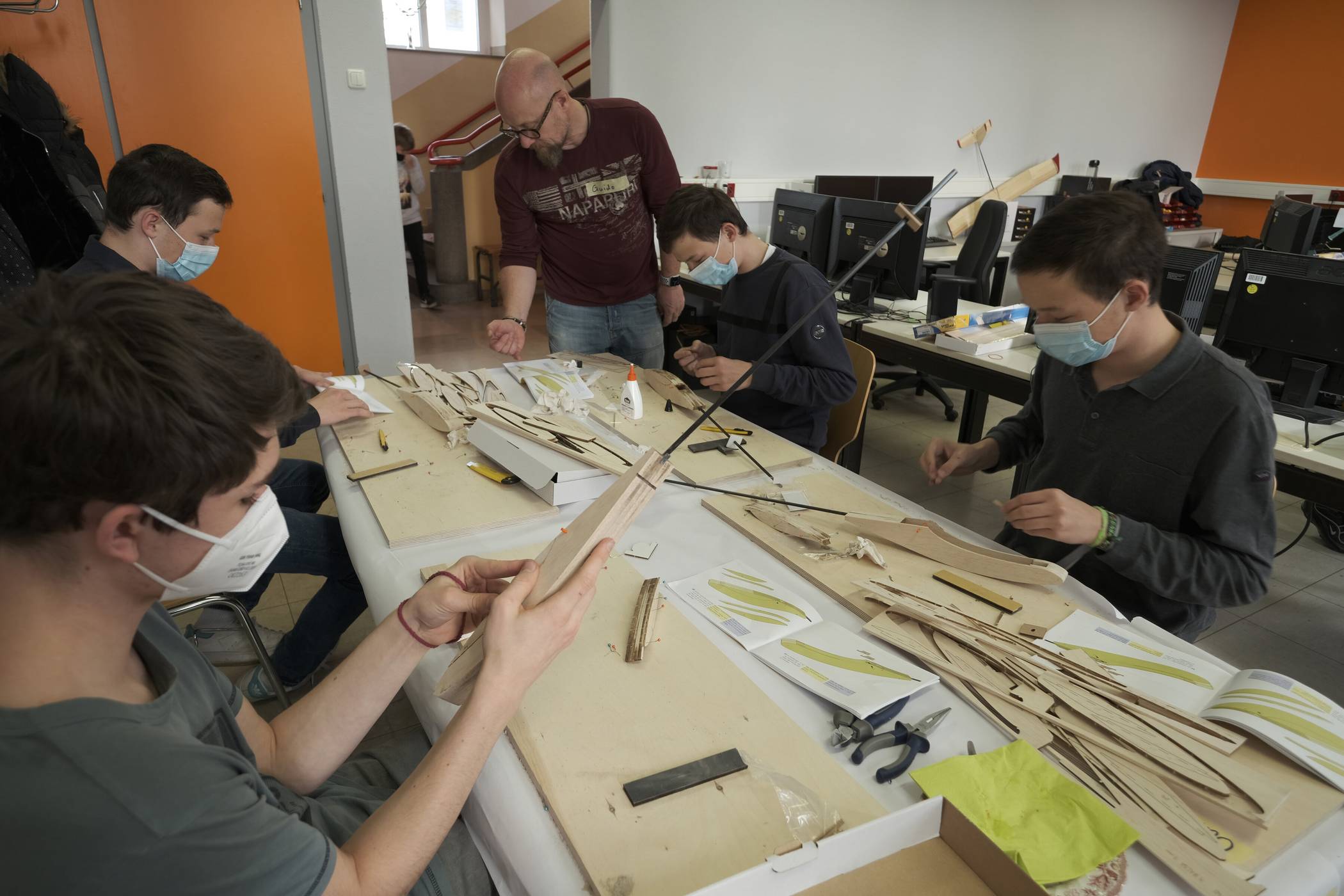  Das Foto zeigt Jugendliche, die im Kurs Avionik 1+2 ein eigenes ferngesteuertes Segelflugzeug aus einem Holzbaukasten der Firma Aeronaut bauen. 
