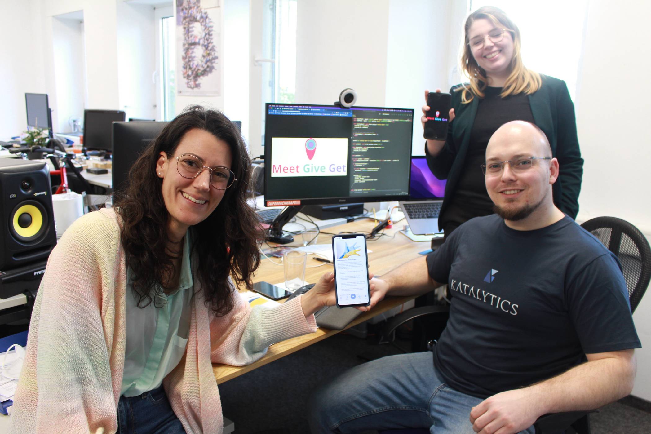  Neue App: Softwareentwickler Alexander Schröer hat in seiner Firma ehrenamtlich die App „Meet Give Get“ entwickelt, die Geflüchtete aus der Ukraine und hilfsbereite Krefelder vernetzt. Webdesignerin Lea Schirmer, die das Logo gestaltet hat, und Organisatorin Nadja Kretschmer (l.) präsentieren auf ihren Smartphones das Ergebnis. Foto: Müller 
