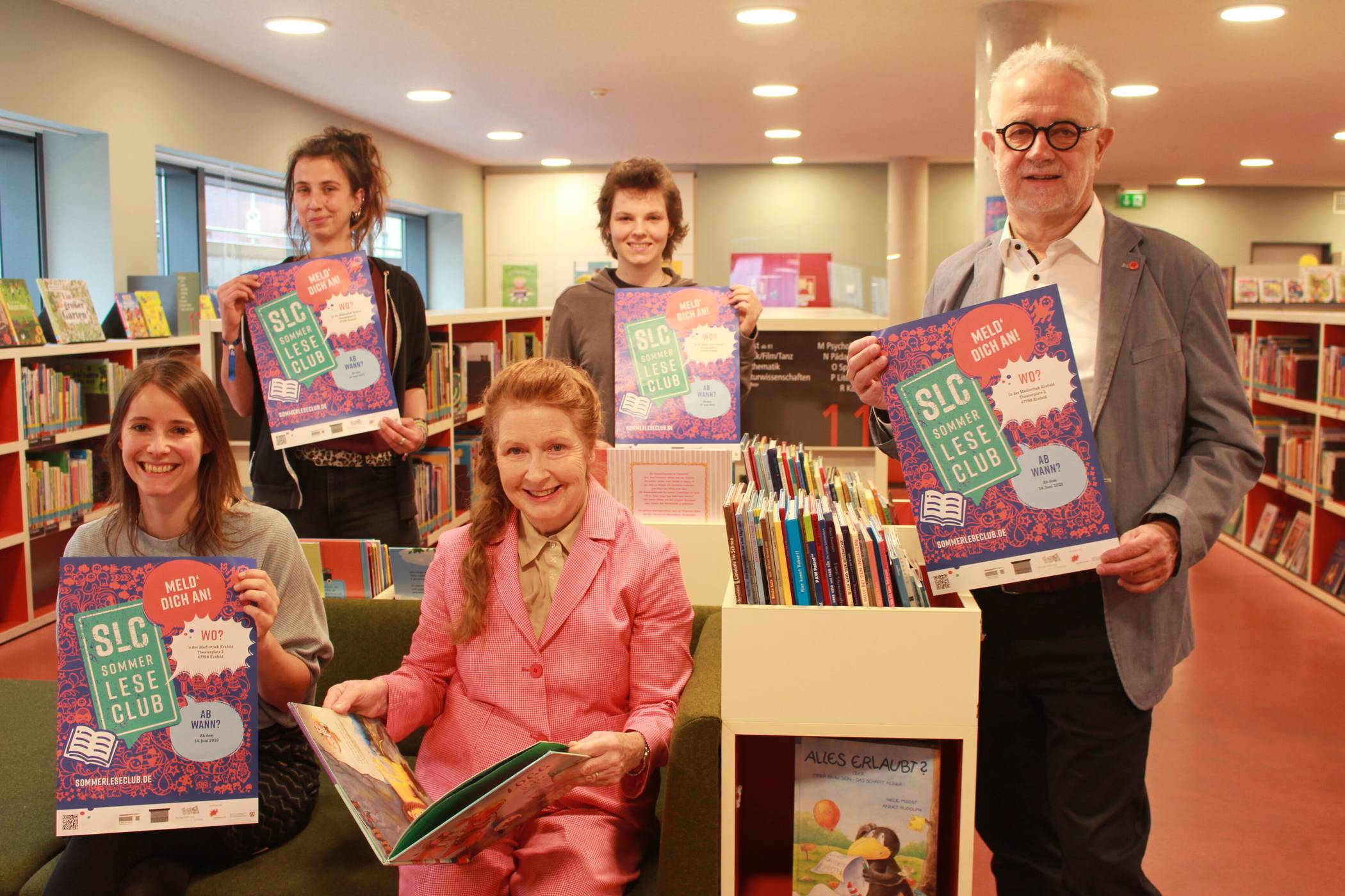  Laden in der Kinderabteilung der Mediothek zum Sommerleseclub ein: Lisa Beutelspacher (l.), Anja Küper (hinten l.) und Saskia Schumann (hinten r.) von der Mediothek organisieren den sommerlichen Lesespaß. Martgit Erbslöh und Dr. Wolfgang Boventer vertreten die Bürgerstiftung Krefeld, die den Sommerleseclub durch ihre finanzielle Förderung ermöglicht. Foto: Müller  