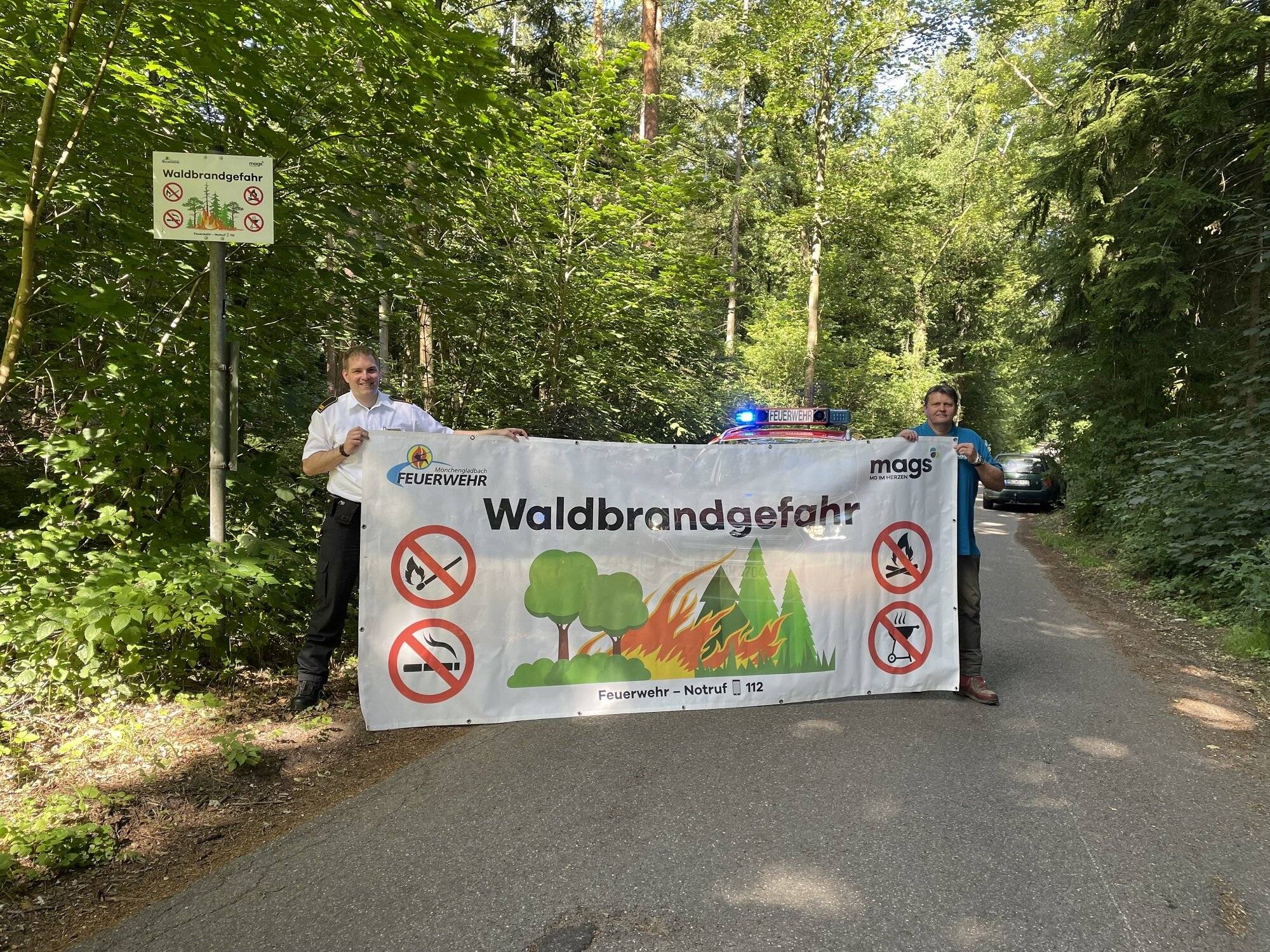  Lars Klausing von der Mönchengladbacher Feuerwehr (l.) und mags-Förster Werner Stops mit einem Banner, der bei hoher Waldbrandgefahr zusätzlich zu den Schildern zum Einsatz kommt. 