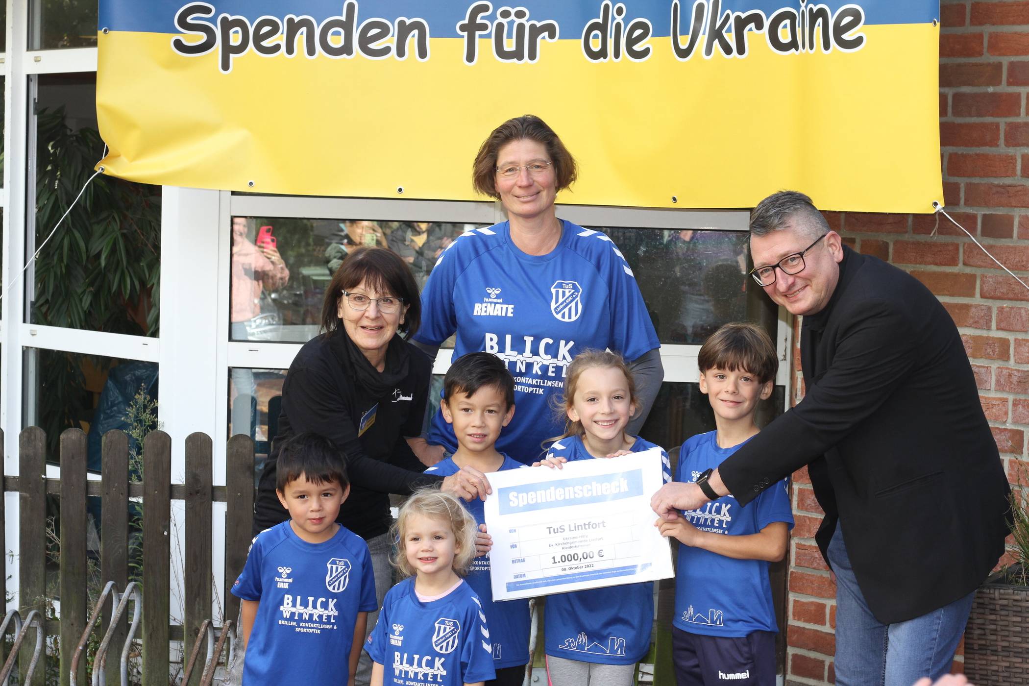 Renate Rusch und einige Kinder der Handballabteilung des TuS Lintfort überreichen die Geldspende an Philipp Zantke und Susanne Reinders, die für die Evangelische Kirchengemeinde in Kamp-Lintfort als Ansprechpartner für die Ukrainehilfe bereit stehen. 