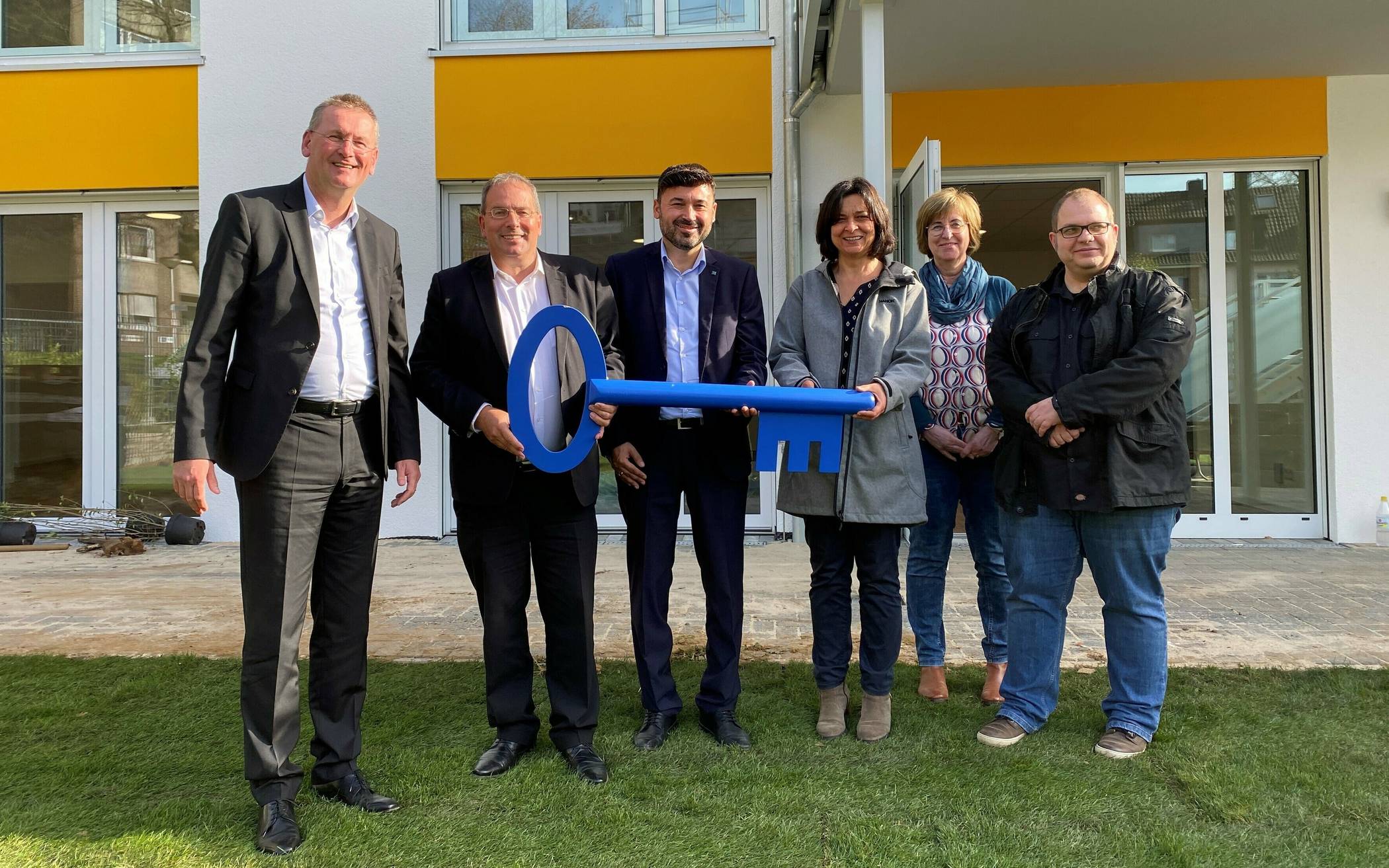  Mit einem großen blauen Schlüssel und im Beisein von Jugenddezernent Ertunç Deniz (3.v.l.) wurde die Kita von VAB-Vorstandsvorsitzendem Albert Becker (2.v.l.) der Geschäftsführerin der Arbeiterwohlfahrt, Nadia Khalaf, übergeben. 