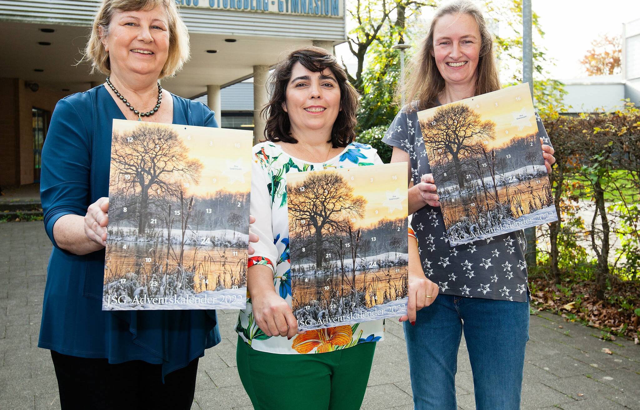   Freuen sich, den JSG-Adventskalender 2022 zu präsentieren: Dr. Susanne Marten-Cleef, Schulleiterin des Julius-Stursberg-Gymnasiums, mit der stellvertretenden Vorsitzenden des JSG-Fördervereins, Natália Rivayo Niewianda, und der Kassiererin Sandra Stückert. 
