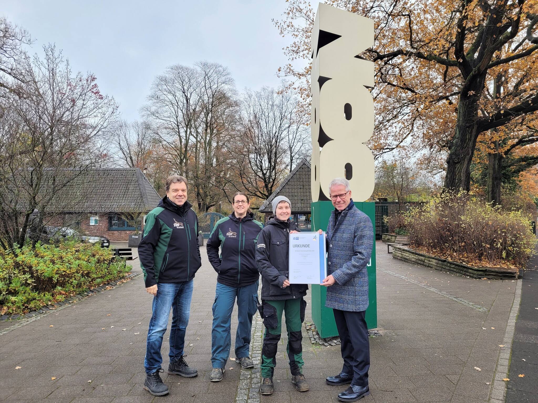 Jürgen Steinmetz (r.), Hauptgeschäftsführer der IHK Mittlerer Niederrhein, überreicht die Auszeichnung des Zoo Krefeld für besonderen Leistungen in der Ausbildung an Simone Gillhuber (2.v.r.), der Landesbesten bei der Abschlussprüfung in der Zootierpflege. Ausbilderin Eva Ravagni (l.) und Zoodirektor Dr. Wolfgang Dreßen freuen sich über den doppelten Erfolg.