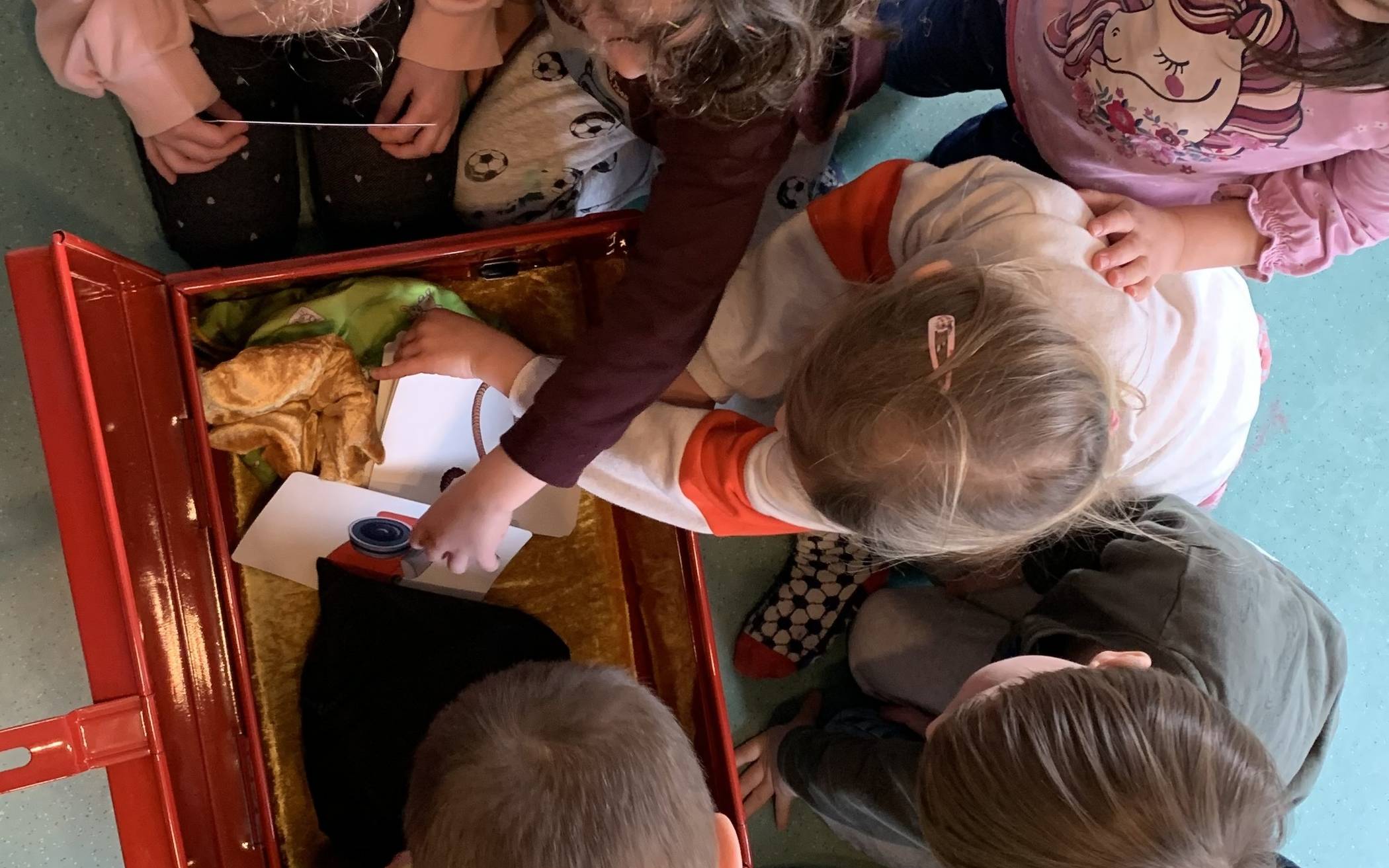  Spielerisch entdecken die Kinder den Inhalt der „Starke Kinder Kiste“ und die Präventionsbotschaften, die hinter den einzelnen Materialien stehen. Das kleine Foto zeigt die Katze Kim.  