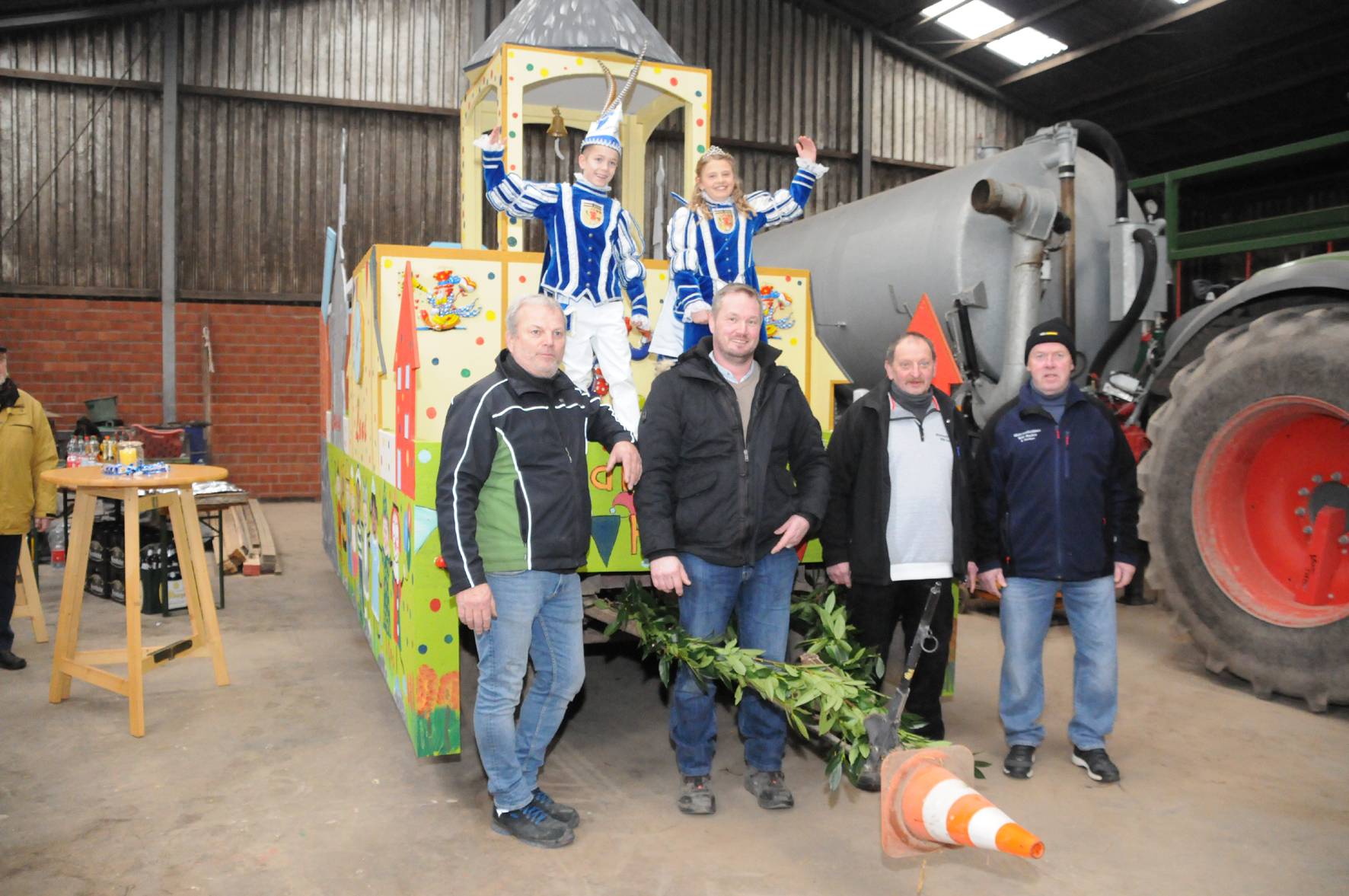  Das Kinderprinzenpaar Lasse I. und Leni I. mit einem Teil der Wagenbauer und Maler auf ihrem schmucken Prinzenwagen in der Halle der Familie Norf. 