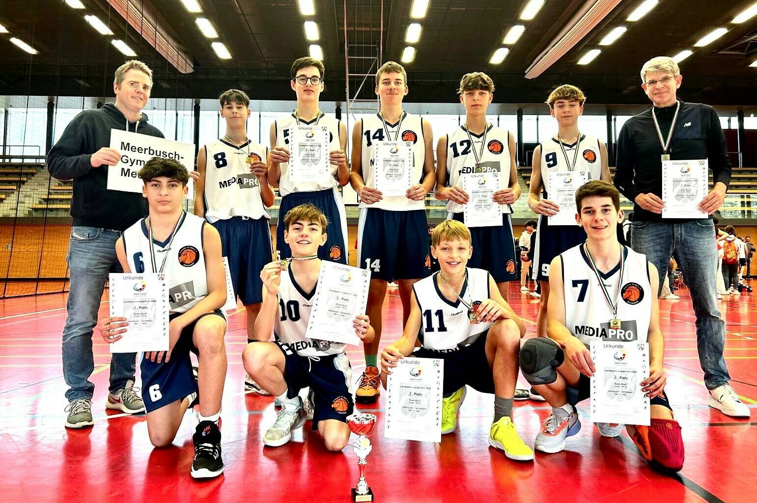 Die Basketball-Jungenmannschaft des SMG freut sich gemeinsam mit Trainer Marc Knuff (l.) und Sportlehrer Arndt Weule über den dritten Platz im NRW Landesfinale. 