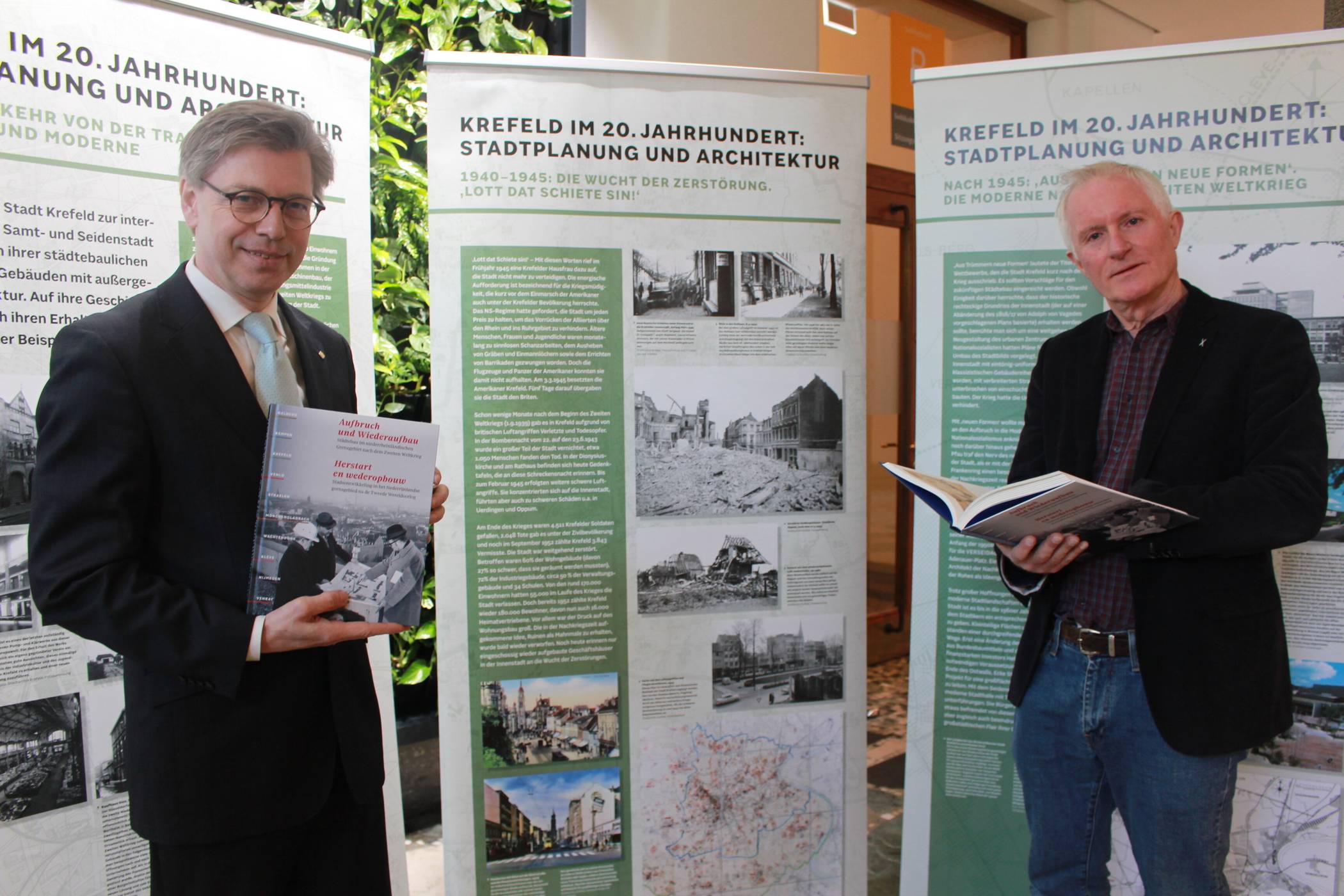 Präsentieren im Foyer des Rathauses Ausstellung und Buch zum Wiederaufbau nach dem Zweiten Weltkrieg: Krefelds Stadtarchivar Dr. Olaf Richter (l.) und Dr. Frans Hermans, Leiter des Gemeindearchivs Venlo. Foto: Müller