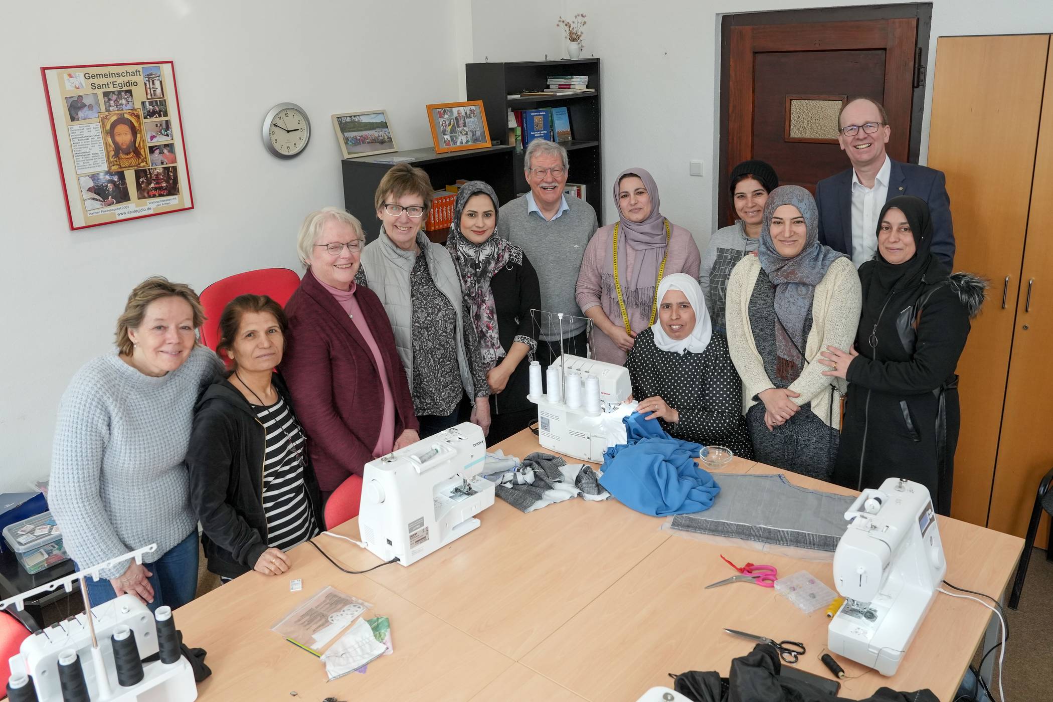 Manuela Brülls (Sant Egidio), die beiden Kursleiterinnen Mechtild Lamers und Beate Meyer, sowie Michael Meyer (Vorsitzender Gemeindienst Rotary) und Franz D. Meurers (Präsident Rotary) mit den Frauen des Nähkurses.   