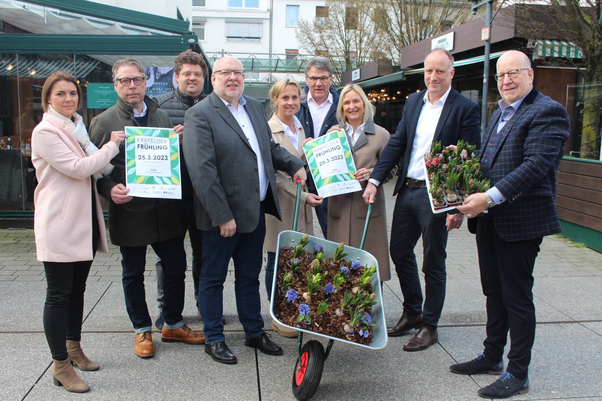 Laden freundlich zum blühenden Krefelder Frühling am 25. März ein: die Werbegemeinschaft unter Vorsitz von Christoph Borgmann (2.v.r.) sowie Krefelds Citymanagerin Dr. Christiane Gabbert (3.v.r.). Foto: Müller