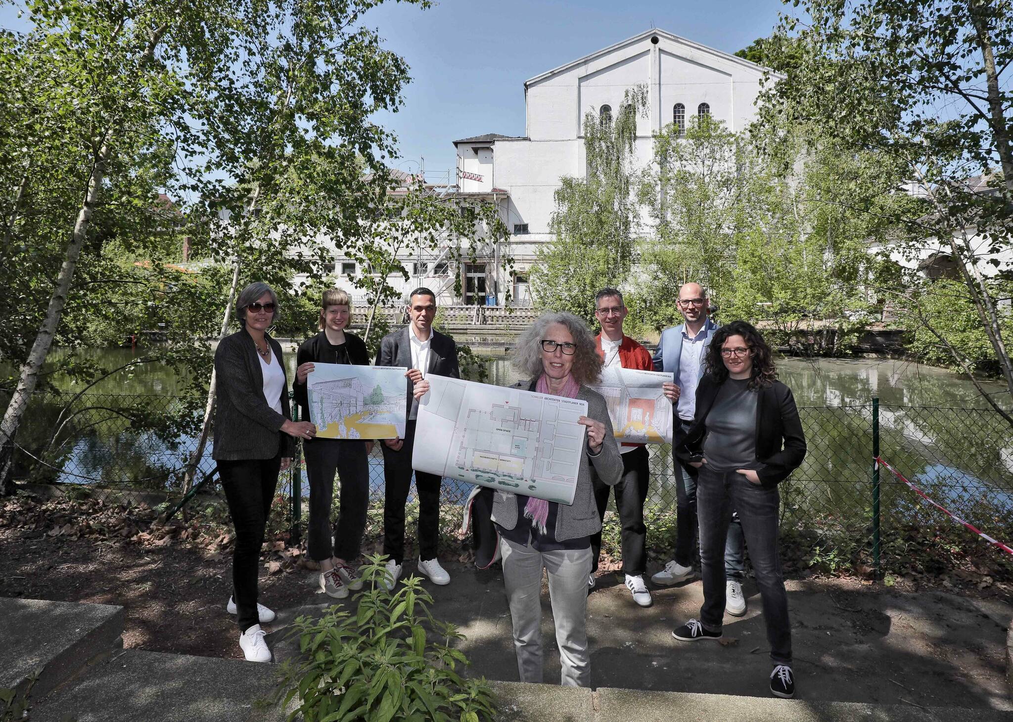 Stellen am alten Freibad die Pläne vor: (v.l.):  Projektmanagerin Ruth Esser-Rehbein, Architektin Lotte Irmler,  Rachid Jaghou vom städtischen Gebäudemanagement, Architektin Kai Mettelsiefen, Marcel Beging vom Verein Freischwimmer, Planungsdezernent Marcus Beyer und Katrin Mevissen  vom Verein Freischwimmer. Foto: Stadt Krefeld, Jochmann