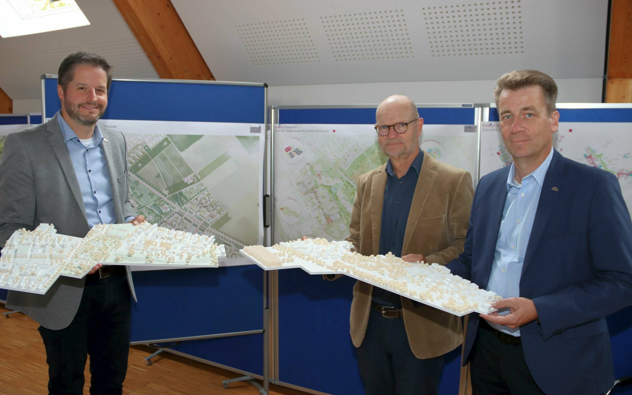  Bürgermeister Christian Bommers, Preisgerichtsvorsitzender Michael von der Mühlen und Andreas Apsel, Technischer Beigeordneter der Stadt Meerbusch (v.l.), präsentieren die Entwürfe der beiden Zweitplatzierten. 