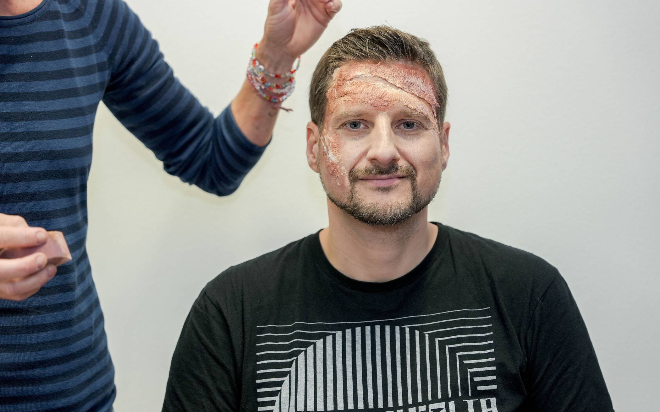 Mit Aqua-Schminke (Braun und Schwarz) und einem Schwämmchen immer wieder über Wunde...