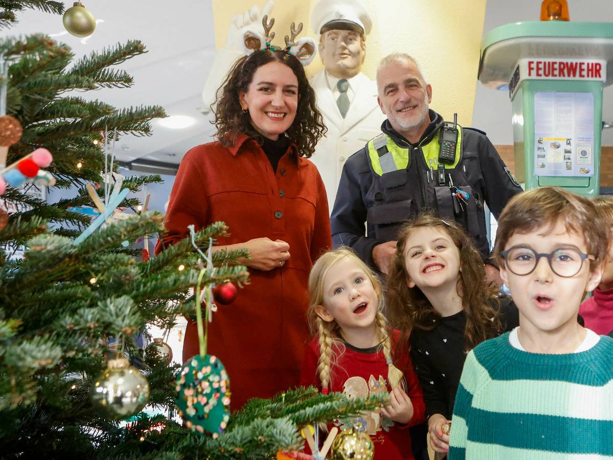 Kinder schmücken Weihnachtsbaum im Polizeipräsidium
