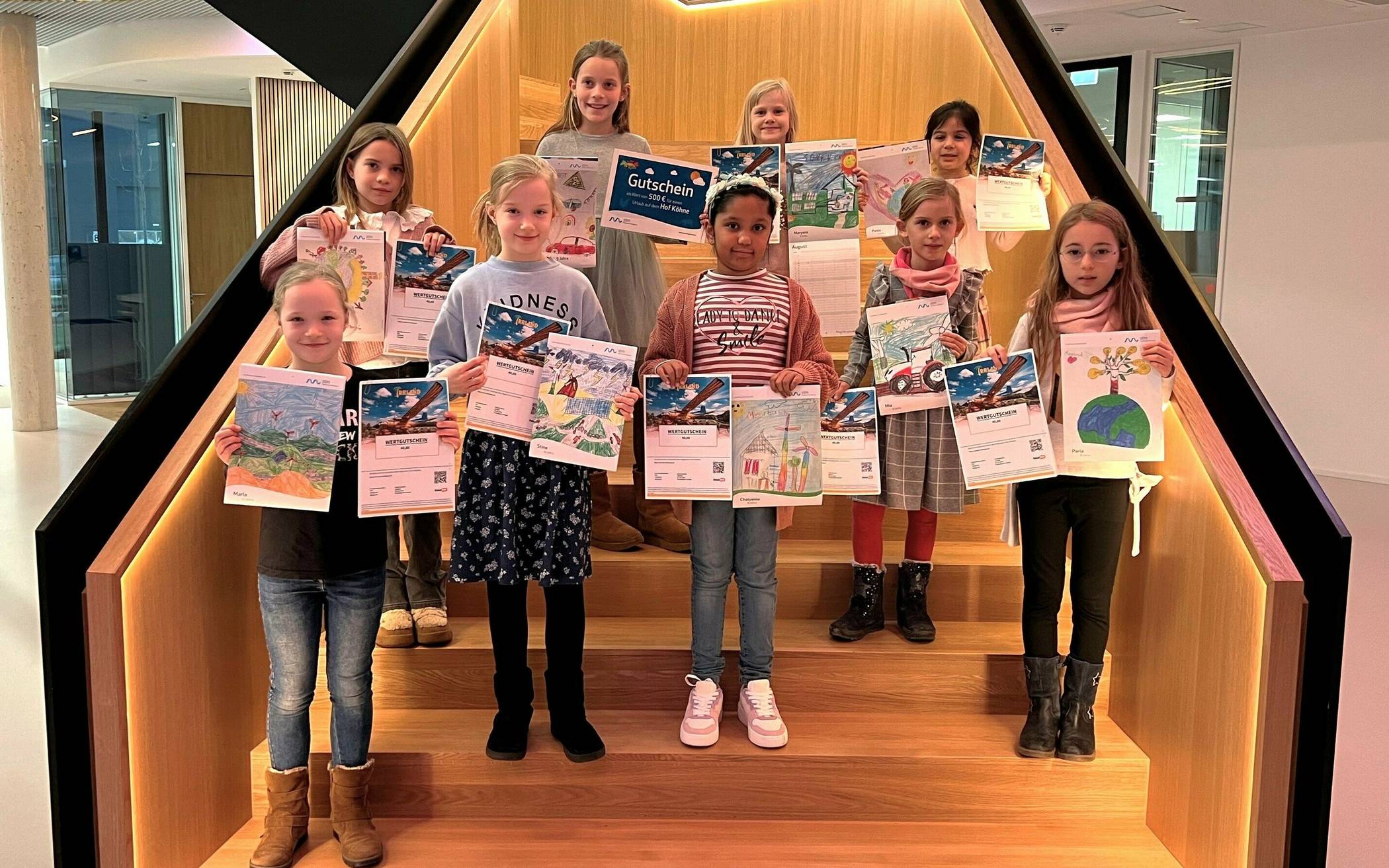  Freuen sich riesig darüber, dass ihre Bilder im Familienkalender 2024 der Stadtwerke gedruckt sind: die neun zur Preisübergabe erschienen Gewinnerinnen aus Meerbusch. 