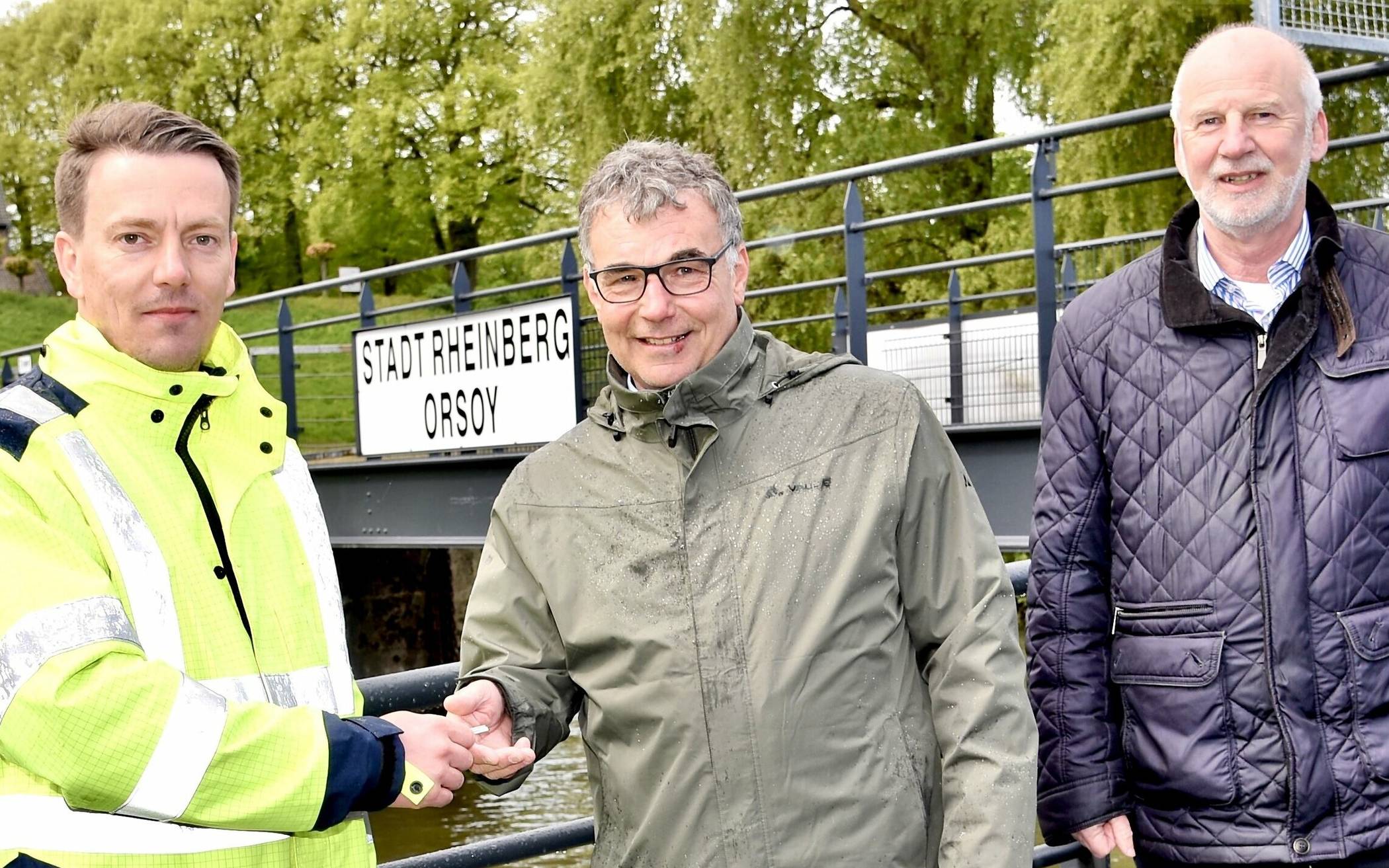 Bürgermeister Dietmar Heyde (Mitte) und Baudezernent Dieter Paus (rechts) nahmen am Tag der Montage den Schlüssel zum neuen Schiffsanleger in Orsoy von Otto Penner (links, Firma SBS Andernach) entgegen. 