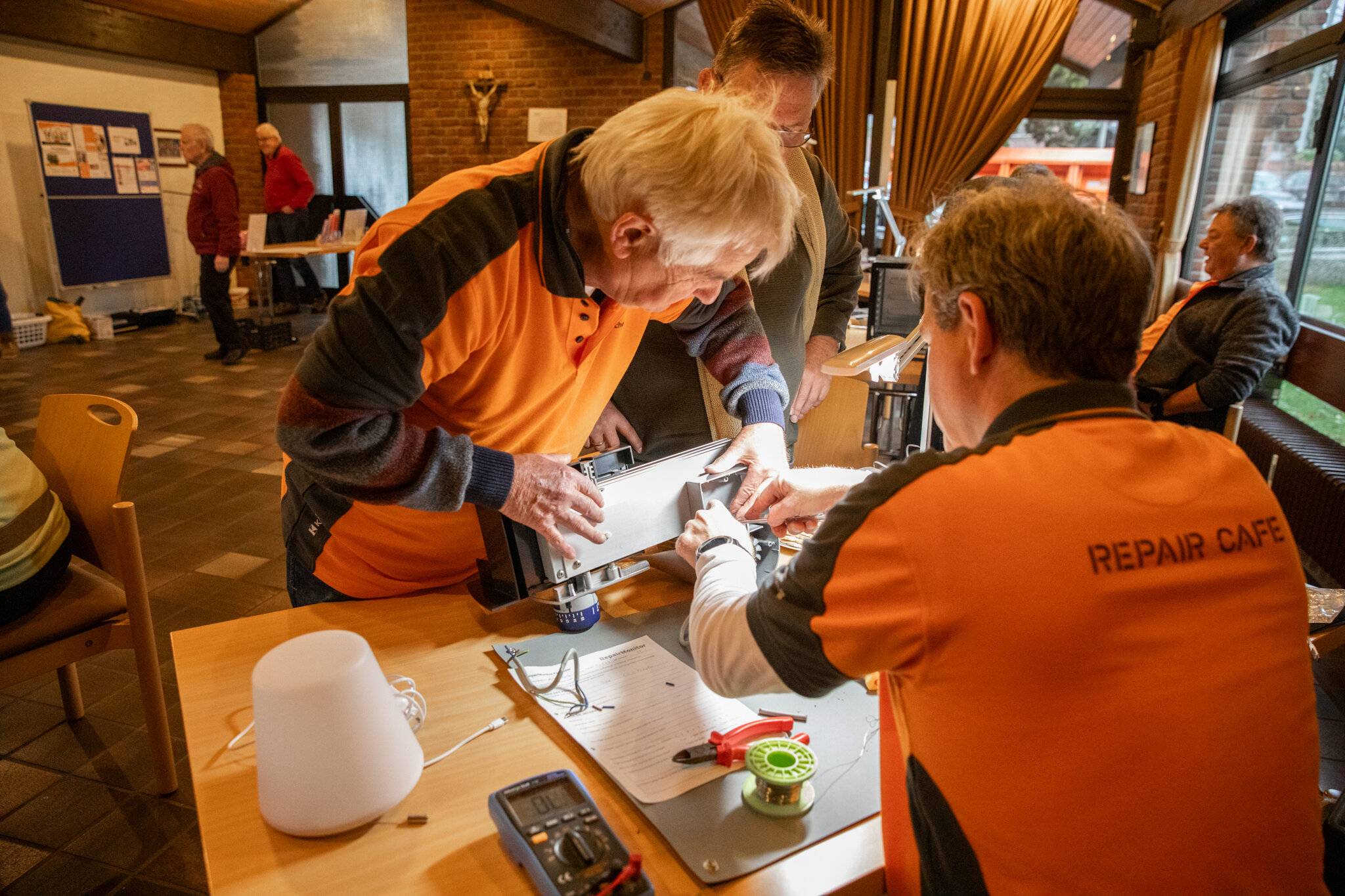 Die Reparatur ist oft Teamarbeit – wie hier bei einer defekten Brotschneidemaschine.