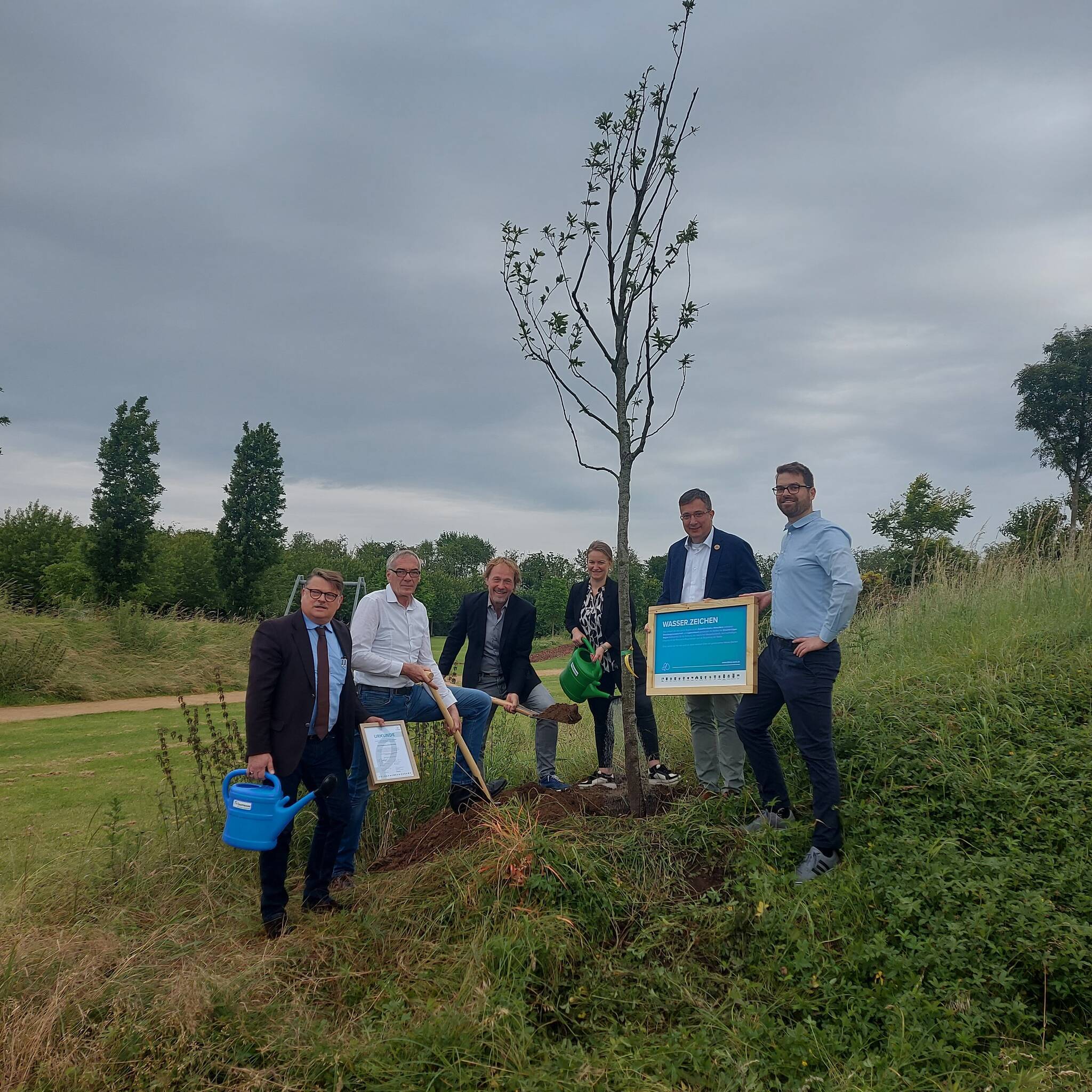  Roland Stud (Vertriebsleiter Knappmann), Bürgermeister Ralf Köpke, Prof. Rainer Sachse (Geschäftsführender Gesellschafter scape Landschaftsarchitekten Düsseldorf), Laura Knappmann (Geschäftsführerin Knappmann), Andreas Giga (Leiter der Zukunftsinitiative Klima.Werk der Emschergenossenschaft) und Bastian Gehrmann (Klimaanpassungsmanager der Stadt Neukirchen-Vluyn). 