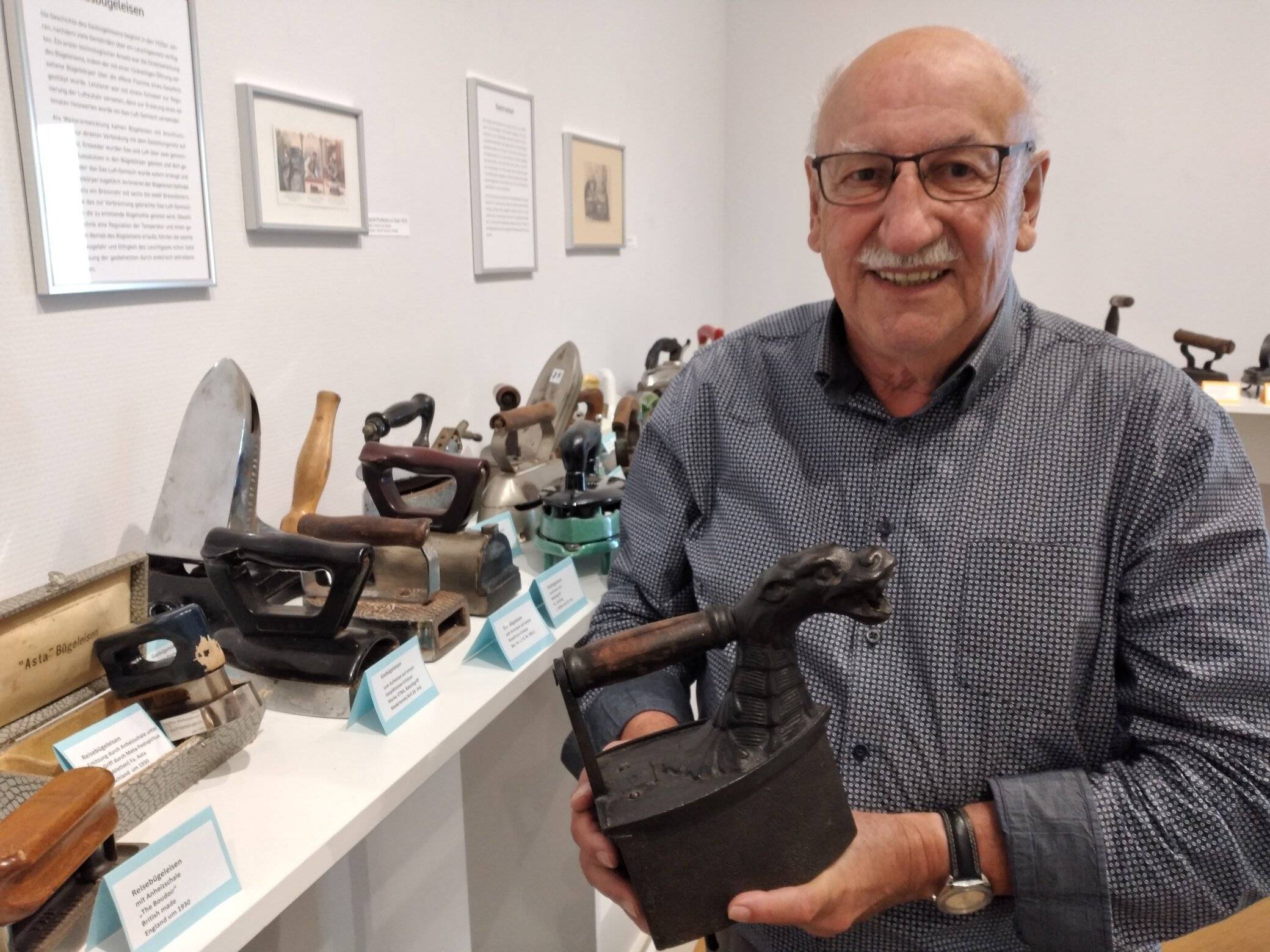  Tolle Exponate: Der Krefelder Sammler Rolf Giesen hat in fünf Jahrzehnten rund 300 Bügeleisen der unterschiedlichsten Epochen zusammengetragen. In der Ausstellung verweist er auf sein Lieblingsstück: ein altes Eisen mit Drachenkopf. Foto: Müller    