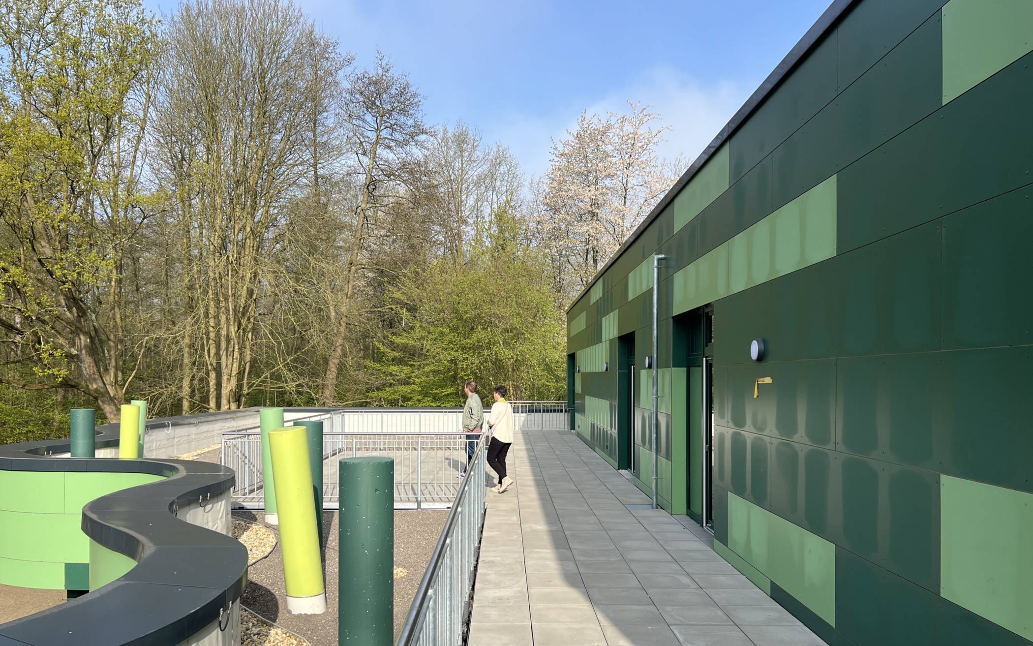 Die grüne Außenfassade der Schule passt sich harmonisch der Umgebung an.