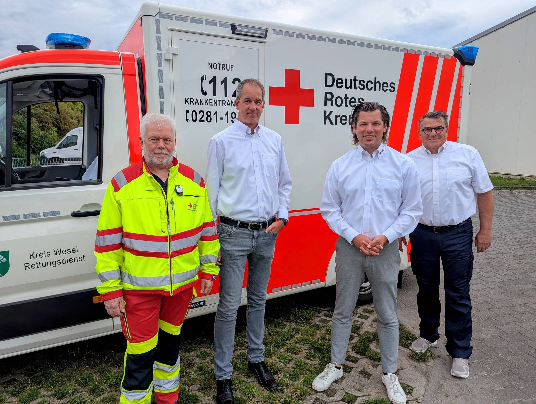  Starkes Team für den Rettungsdienst: (v.l.n.r.): stellv. Betriebsratsvorsitzender Mathias Hangert, DRK-Präsident Jan Höpfner, Vorstand Andreas Bußmann und Geschäftsbereichsleiter Notfallvorsorge Ludger Ferdenhert vor einem Einsatzfahrzeug des DRK-Kreisverbands Niederrhein 