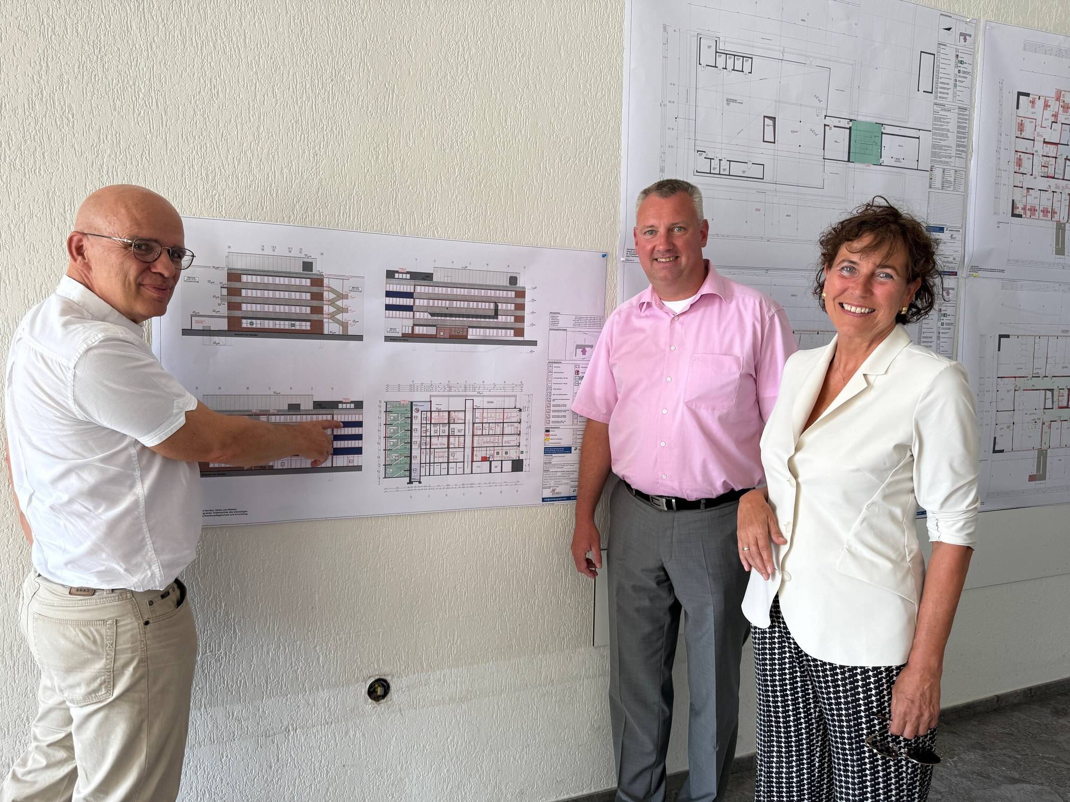Der Geschäftsführer des AKH, Dr. Thomas Axer, erläutert die Umbaupläne dem Verwaltungsratsvorsitzenden Michael Aach und Bürgermeisterin Sabine Anemüller schauen sich die Pläne an (v.l.). 