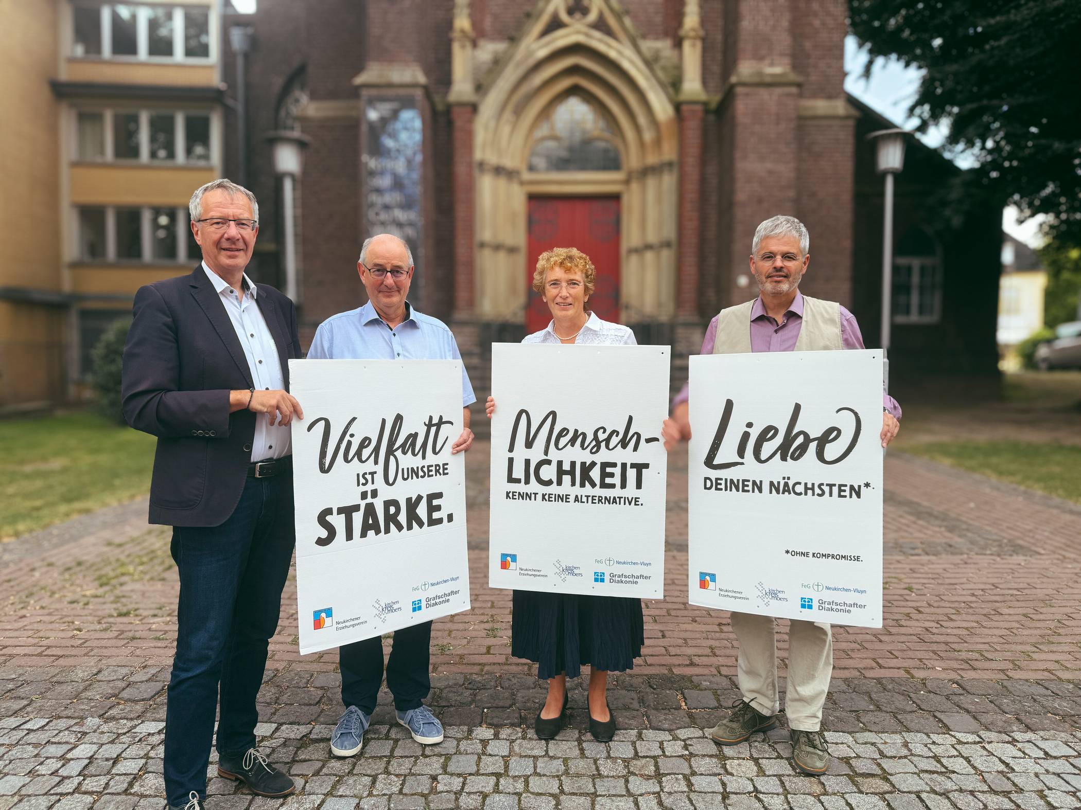  Superintendent Wolfram Syben, Thomas Simon, FeG Neukirchen-Vluyn, Direktorin Annegret Puttkammer und Kai Garben, Gf Grafschafter Diakonie präsentieren die Plakate. 