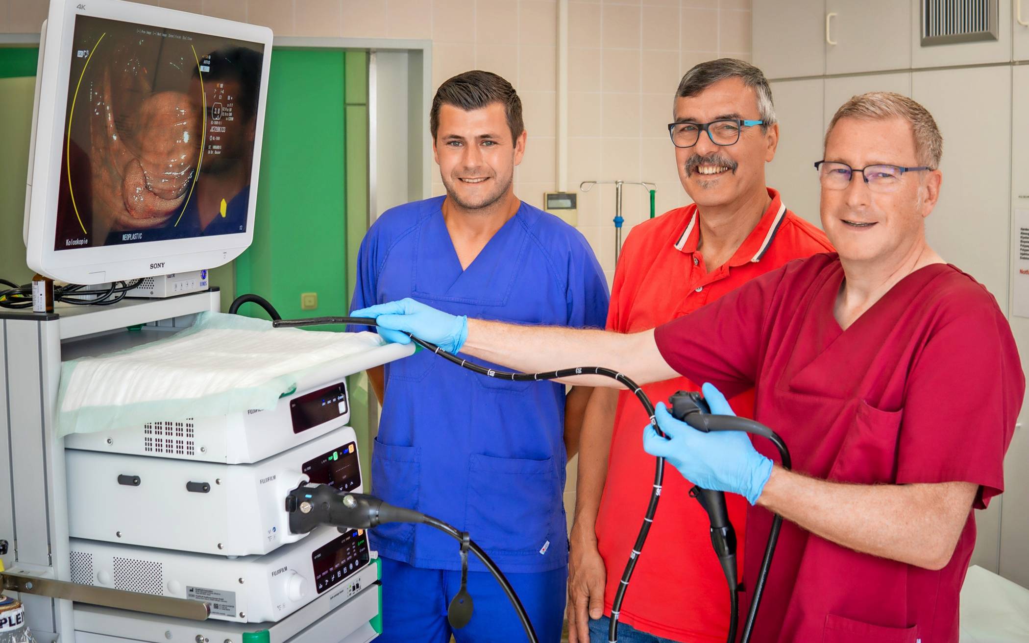  Dr. Ulrich Bauser, Chefarzt Klinik für Innere Medizin,  (r.) und Michel Scholten-Buhro, Pflegefachleitung,  zeigen Klaus Lehmgrübner, wie künstliche Intelligenz bei der Darmspiegelung unterstützt.  