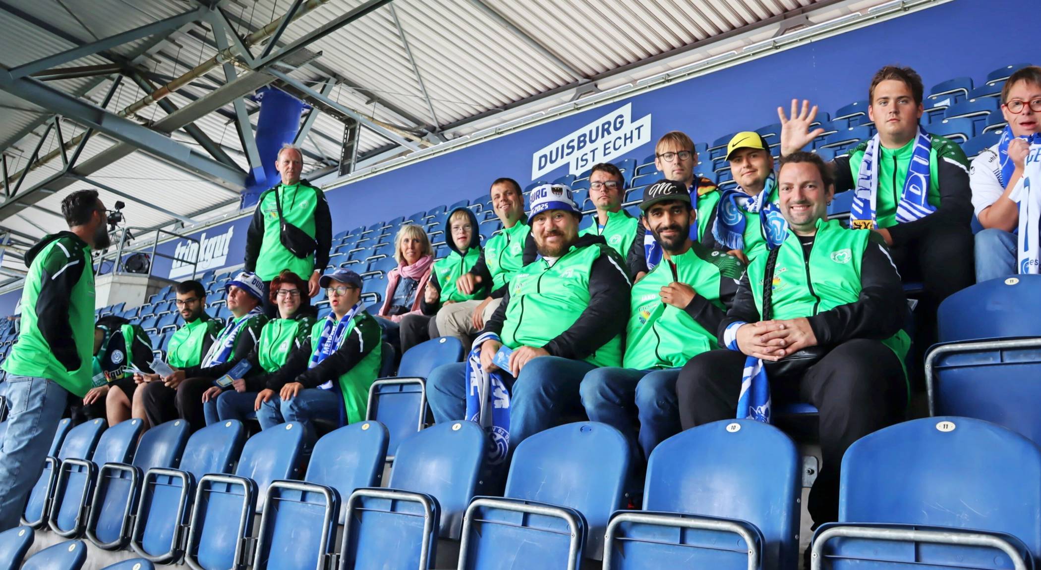 Die Mannschaft der Caritas Kickers aus Moers stimmt sich auf der Tribüne des MSV Duisburg auf das Spiel gegen den SV Wehen Wiesbaden ein. 