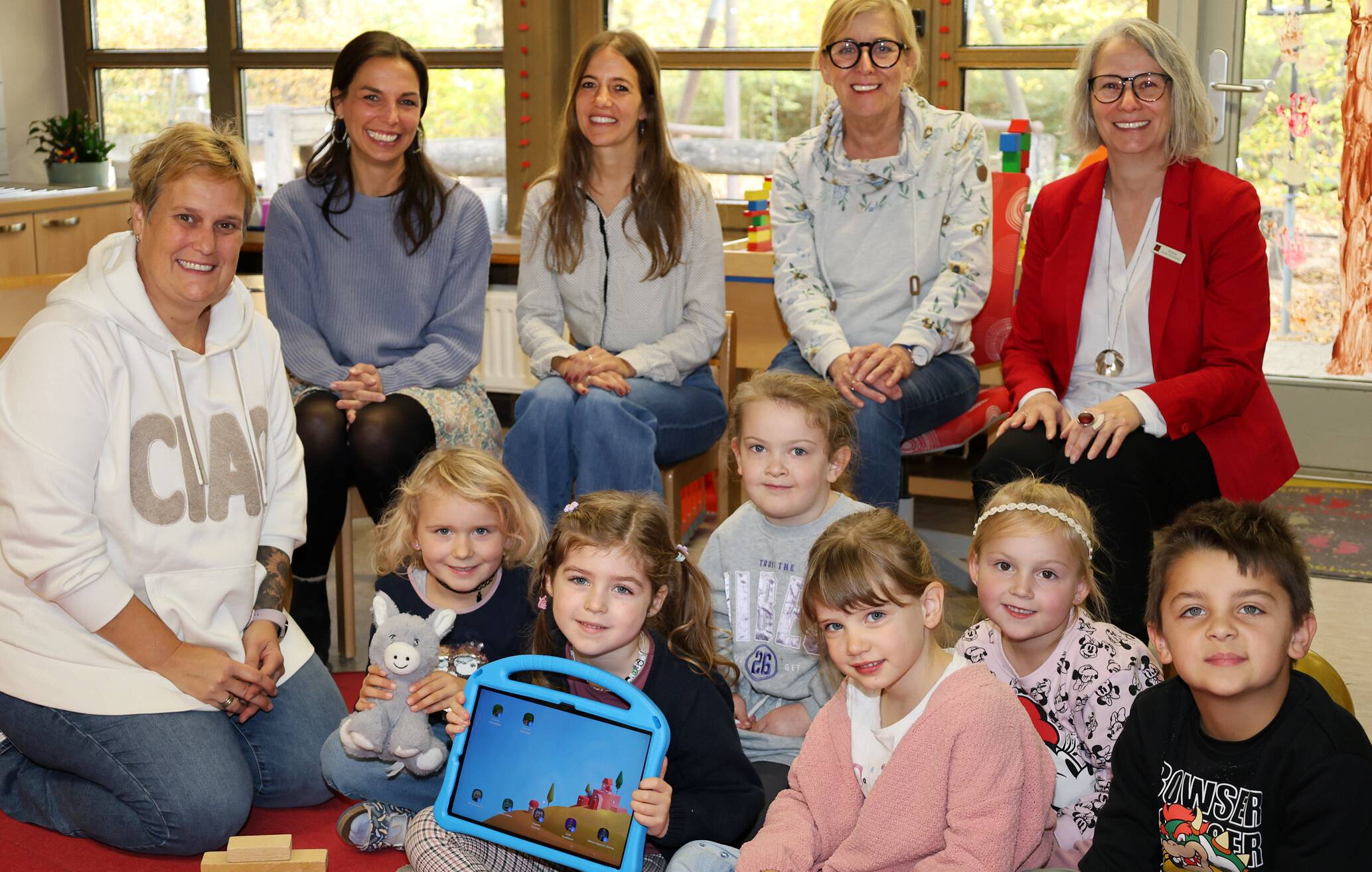  Das neue Tablet nutzen insgesamt 14 Maxi-Kinder der St.-Peter-Kita, um gemeinsam etwas zu entdecken, selbst gemachte Fotos zu animieren oder eigene Bilderrätsel zu machen. Dabei werden sie stets von Silke Geerkens (l.) begleitet. Veronika Tekülve und Nadja Schmitz vom Förderverein, Kita-Leiterin Hildegard Joswig und Andrea Kabs-Schlusen von der Sparkasse finden den kontrollierten Umgang mit neuen Medien für Vorschulkinder gut. 