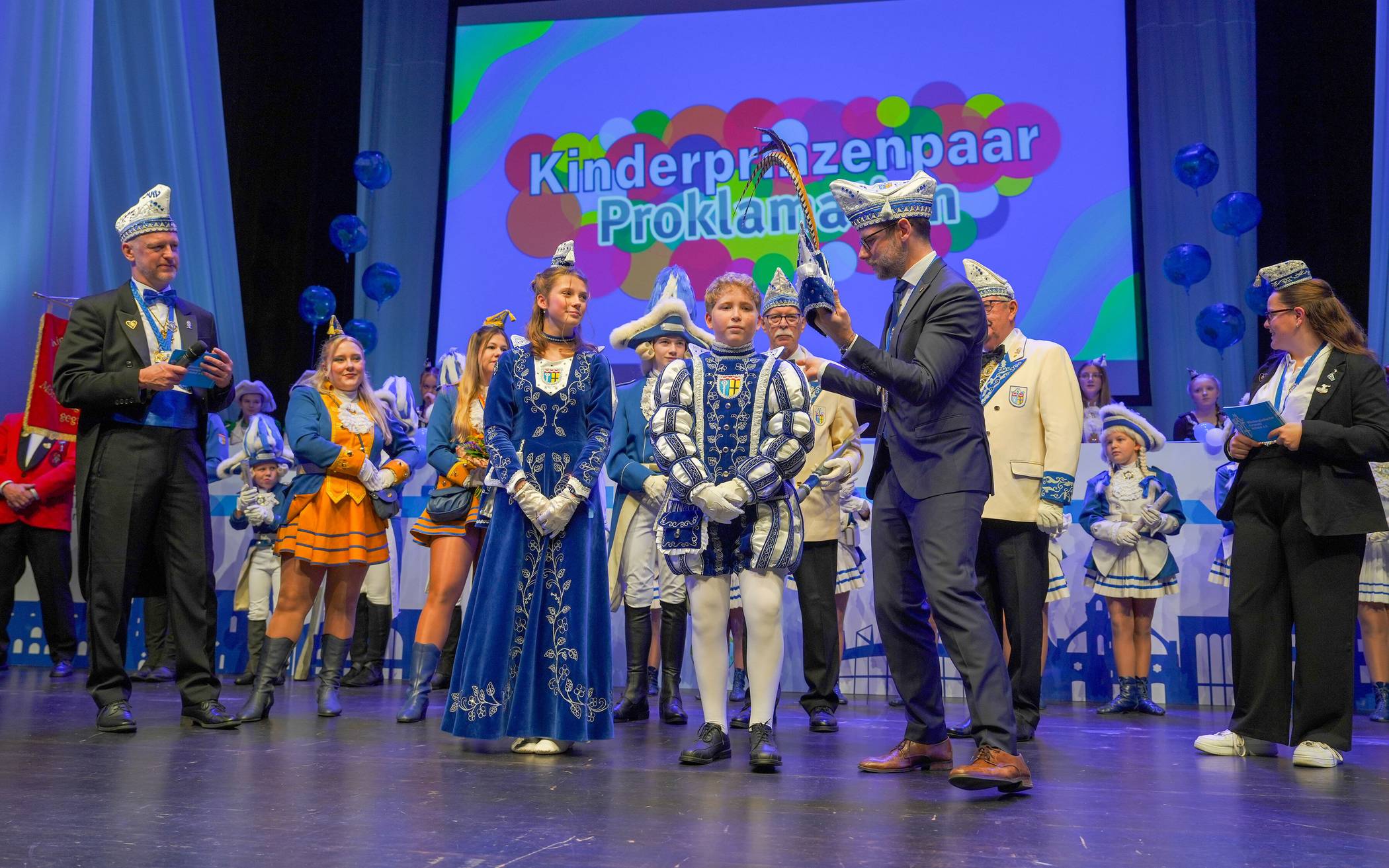 Der OB steht mit der Prinzenmütze mit Federn...