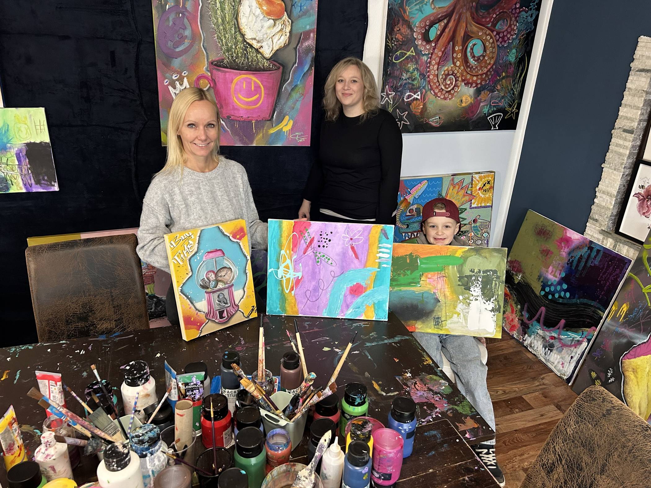  Nicole Akgül-Beskes (l.) von Choose Happiness und Künstlerin Betty Schraven haben die Ausstellung organisiert. Mit dabei Schravens Sohn. 