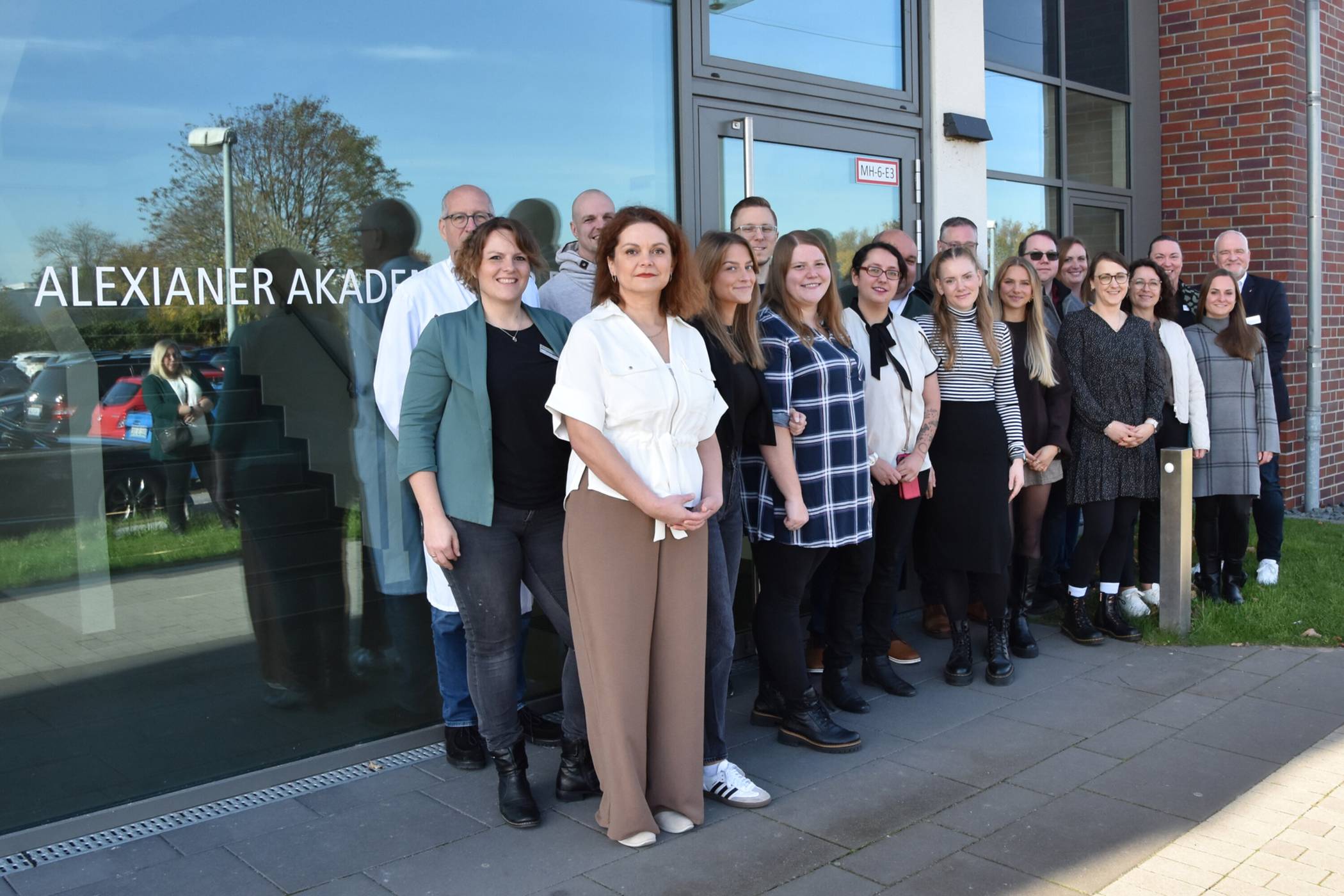  Acht zur Praxisanleitung weiterqualifizierte Pflegefachkräfte feiern ihren Abschluss, umrahmt von Lehrenden, Akademie- und Betriebsleitung der Alexianer Krefeld GmbH. 